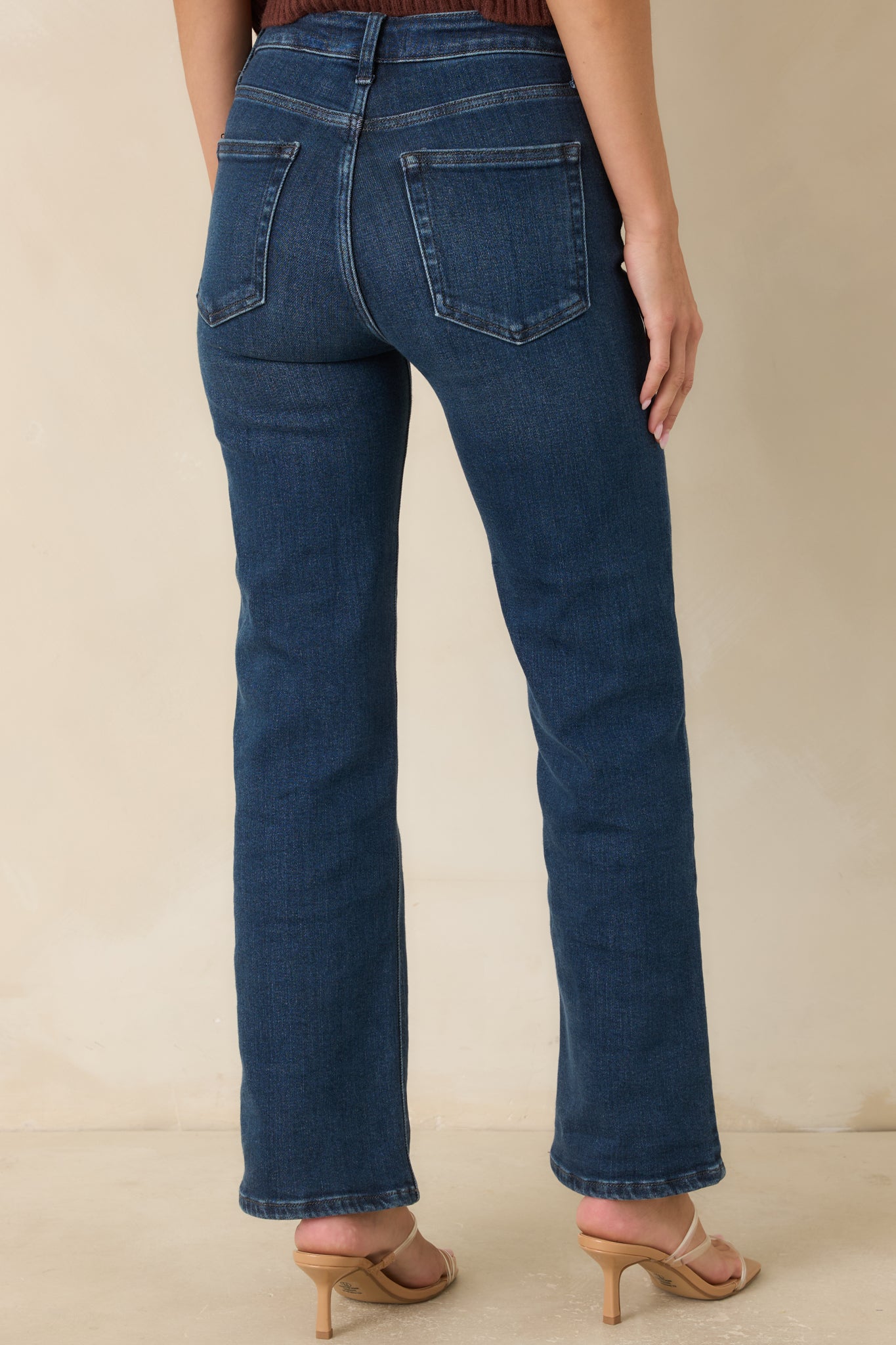 Back view of the medium wash jeans featuring a straight-leg fit, back pockets, and subtle fading throughout.