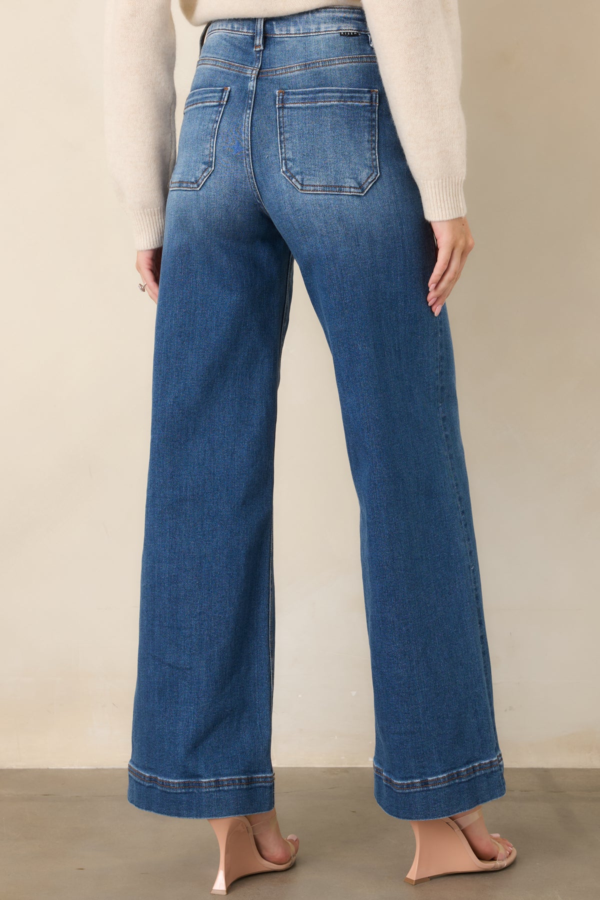 Rear of medium wash jeans showing contoured back yoke and wide legs.