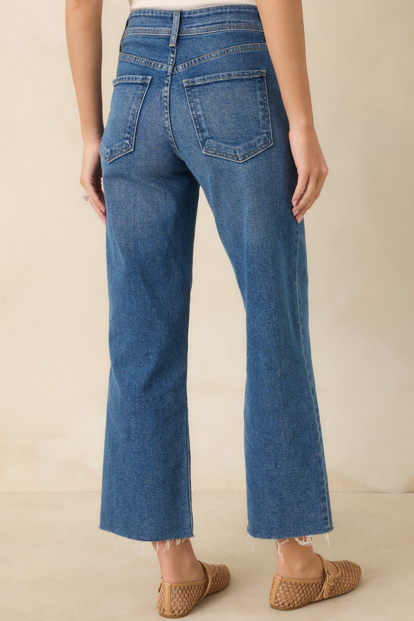 Back view of medium wash utility jeans featuring back pockets, belt loops, and wide-leg silhouette.