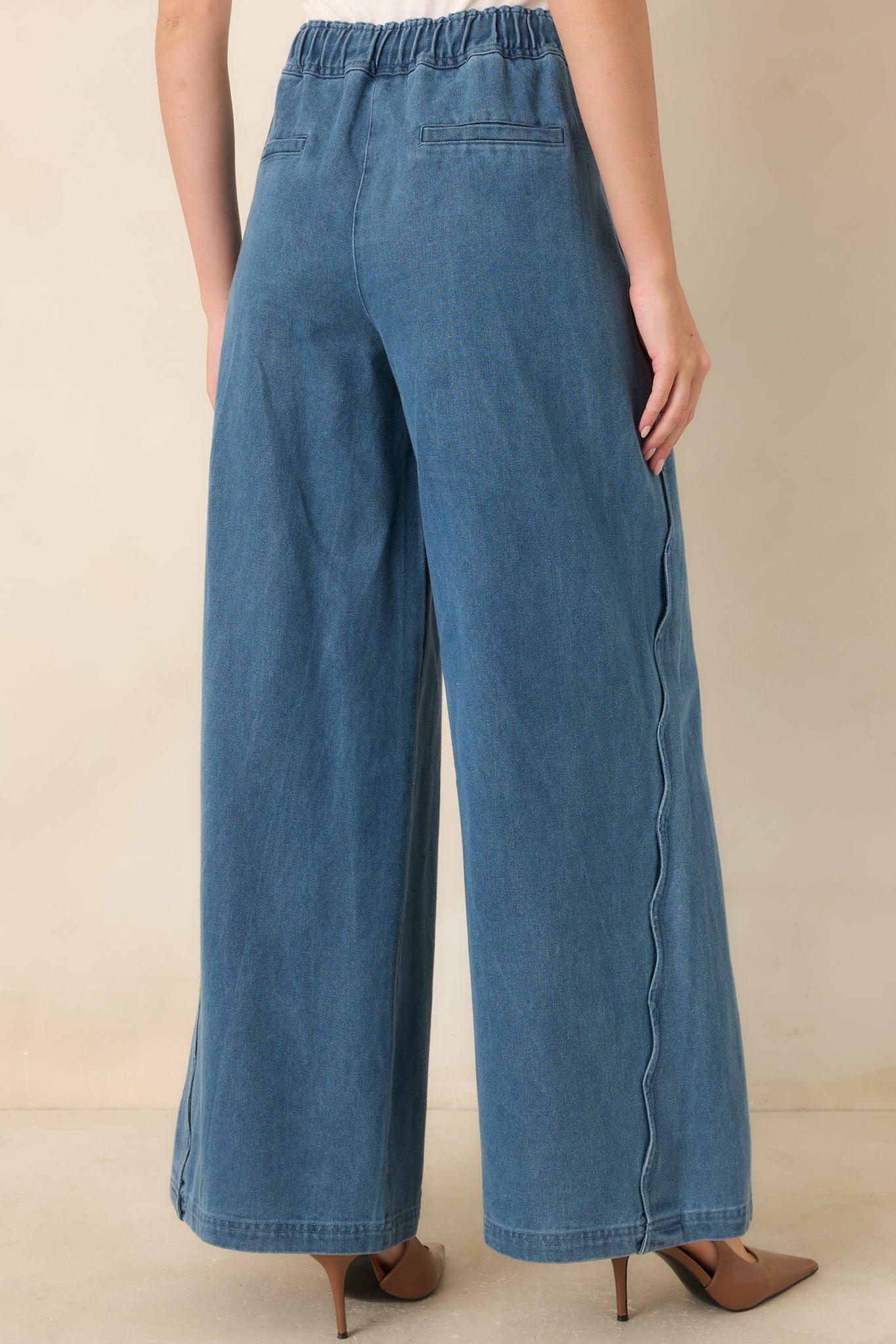 Rear view of medium wash wide leg jeans featuring a high-rise fit and relaxed wide leg silhouette with clean denim styling.