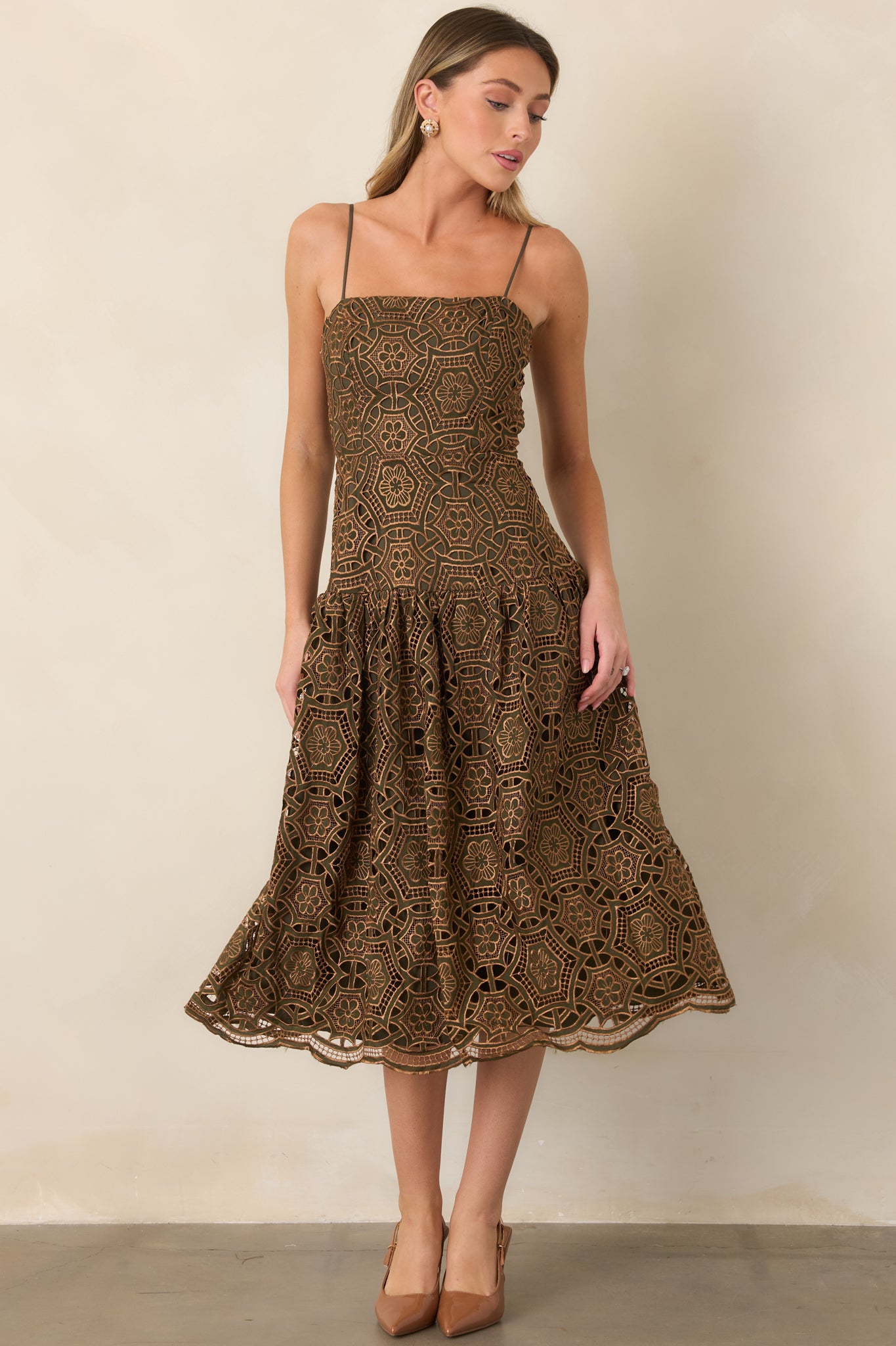 Metallic lace overlay dress featuring delicate spaghetti straps, a streamlined bodice, and a flowing gathered midi skirt.