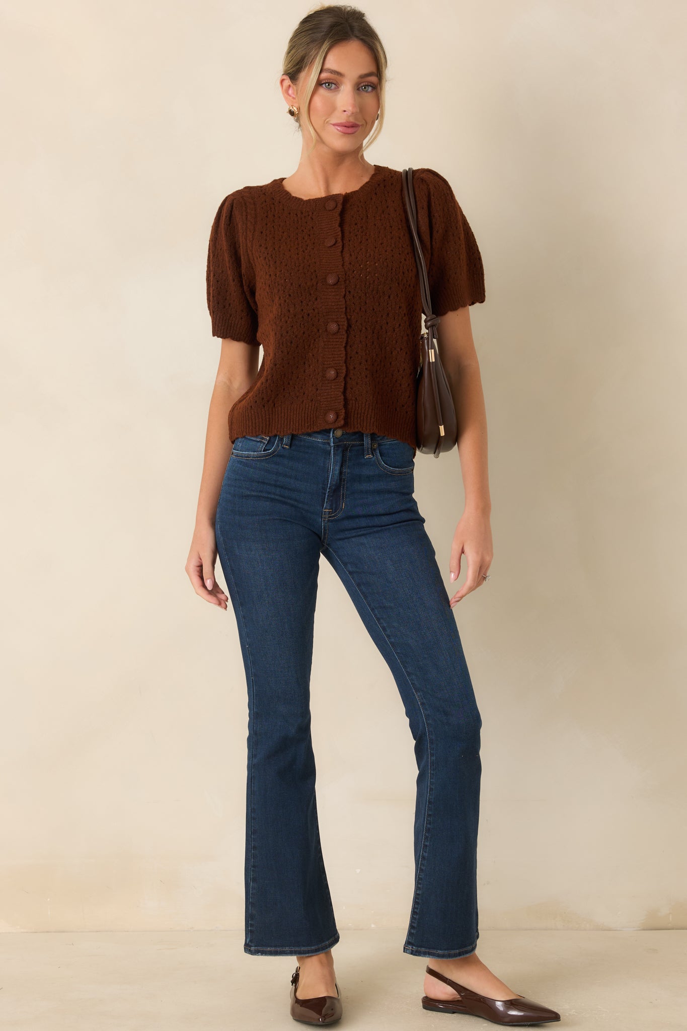 Mid-rise dark denim flare jeans featuring traditional five-pocket styling, contrast stitching, and a sleek fit through the hips and thighs.
