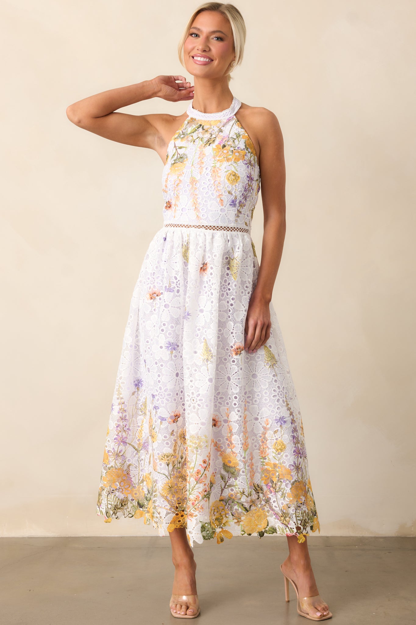 This midi dress stuns with its embroidered floral overlay, detailed with eyelets and a fitted waist.