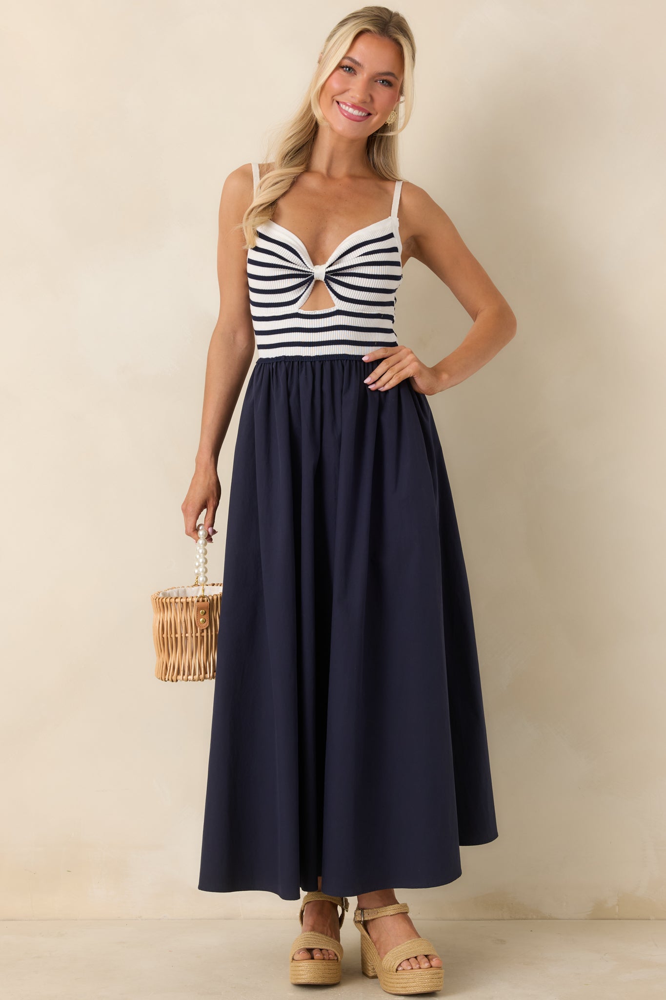 Midi dress featuring adjustable straps, gathered maxi skirt, and flowing silhouette.