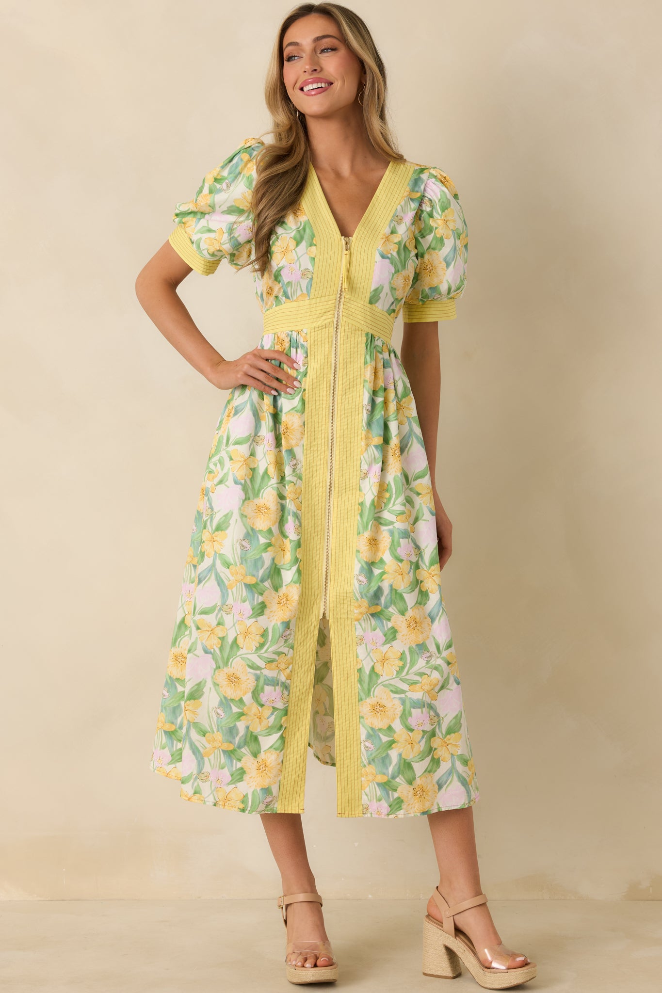 Floral yellow midi dress in lightweight cotton with a fitted waistband, puff sleeves, zip-front V-neckline, and a skirt featuring a modest front slit.