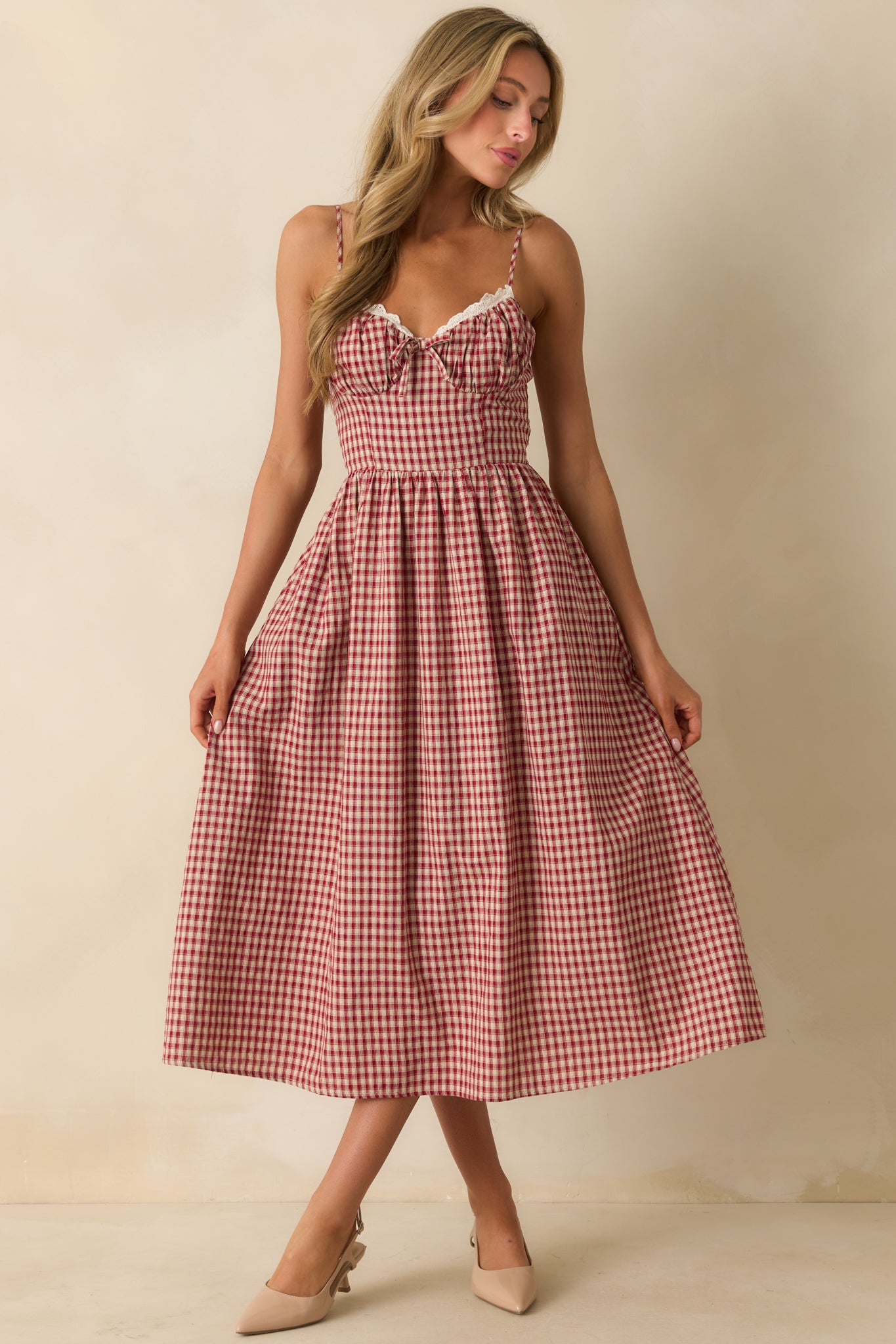 Midi dress in red gingham with front bow accent, pocket detail, and smocked back for added stretch.