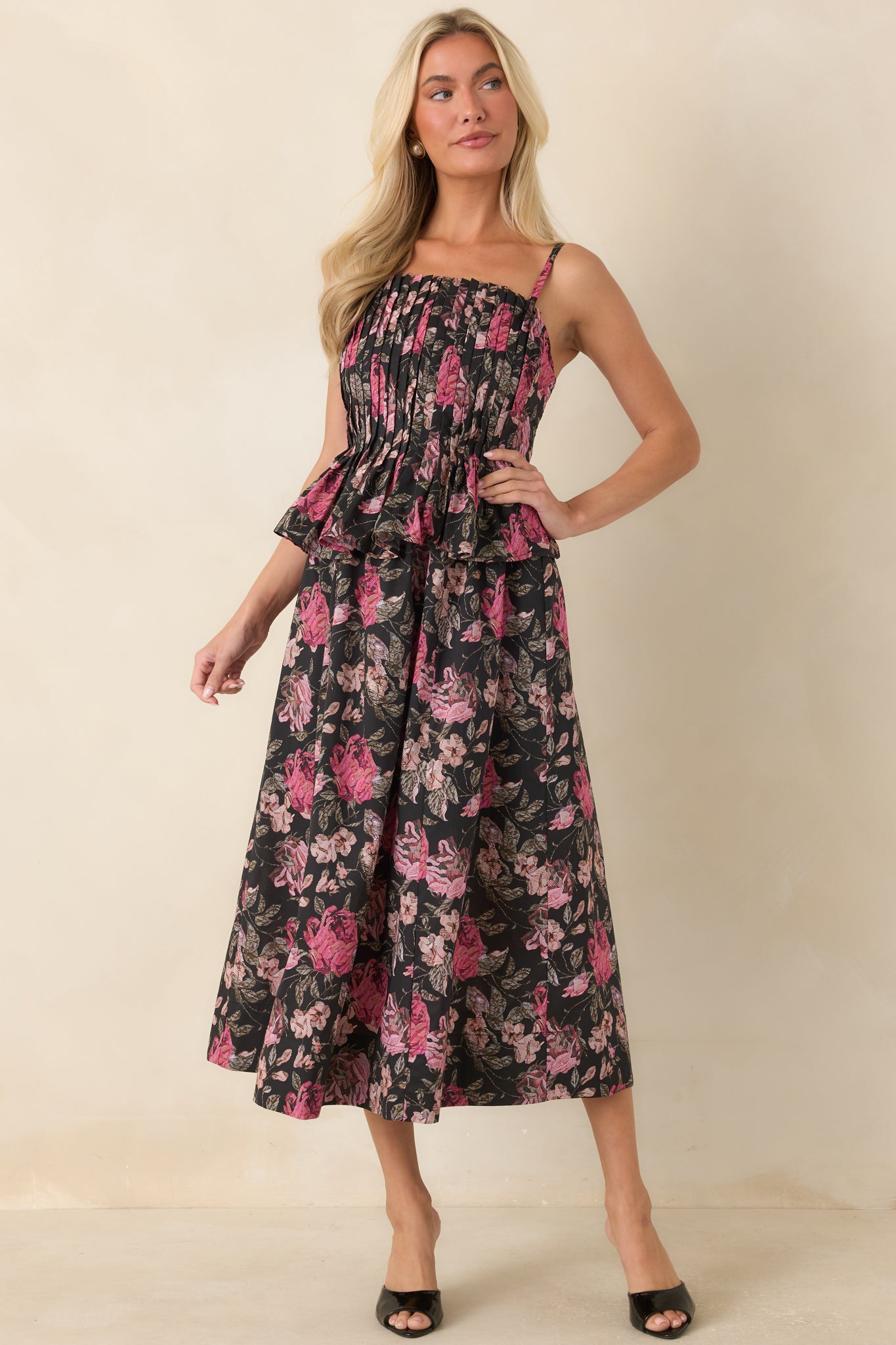 Midi dress featuring a layered peplum accent, allover floral print, and an elegant full silhouette.