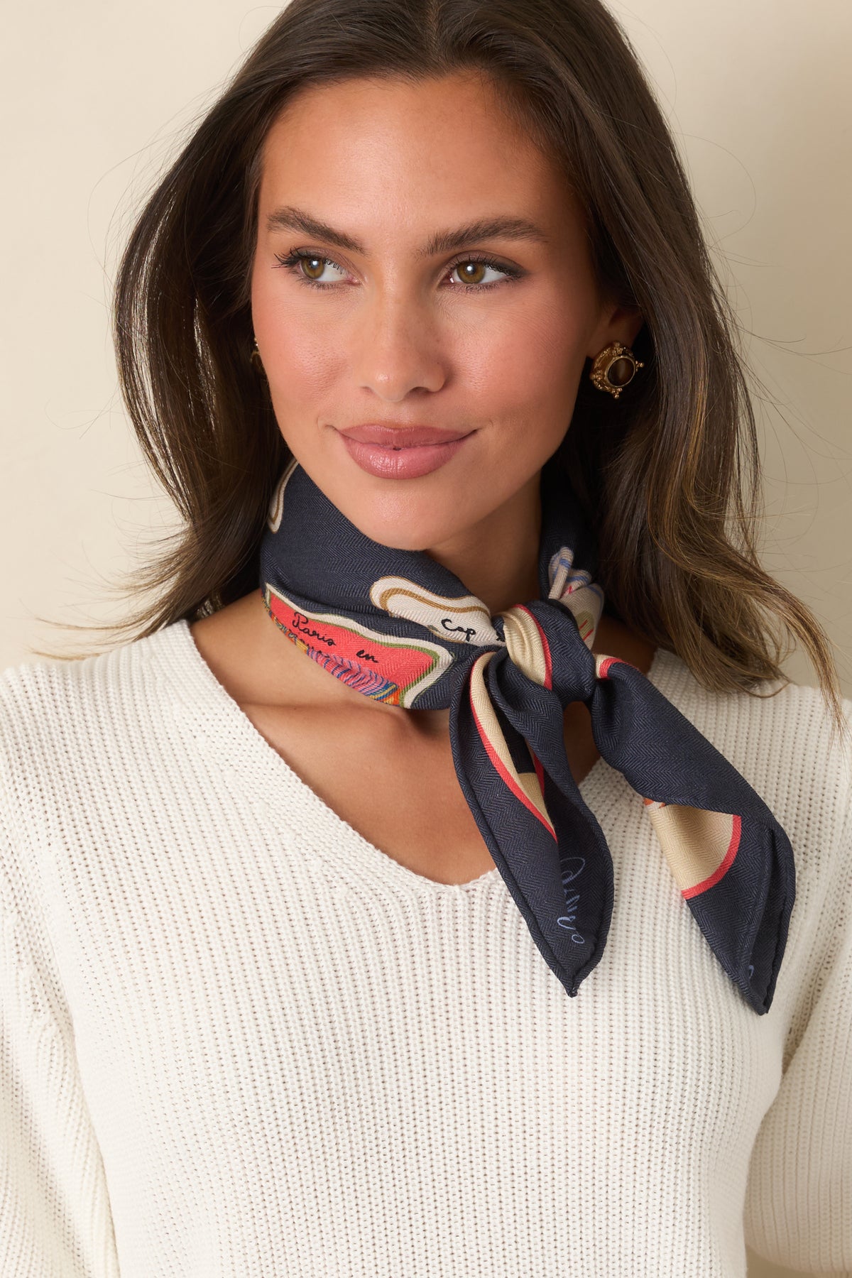 Midnight blue hair scarf featuring colorful illustrated travel, café, book, floral, and everyday motifs framed by a scalloped ivory border.