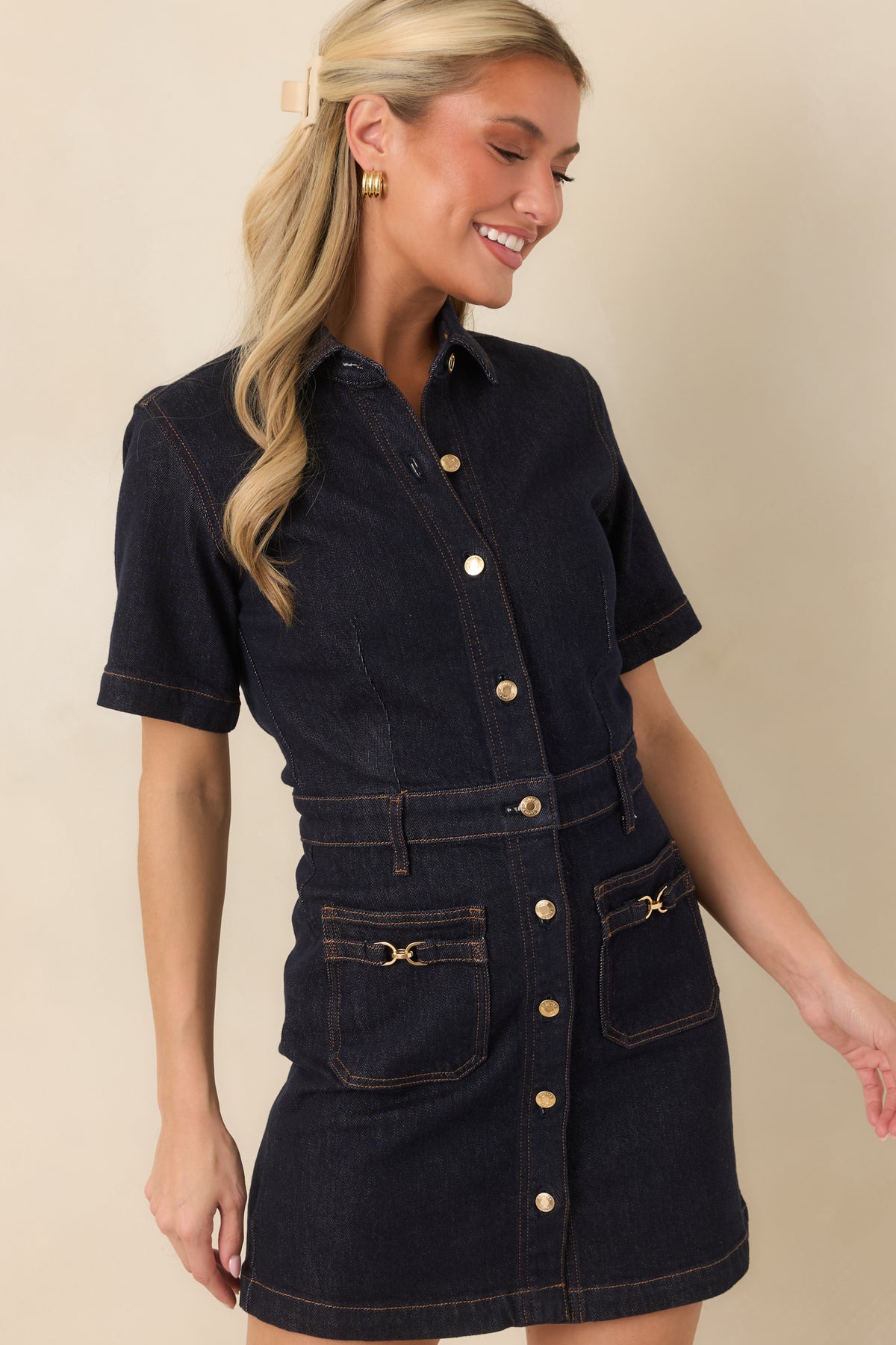 Midnight denim dress highlights its pointed collar, gold-tone button placket, and short sleeves.