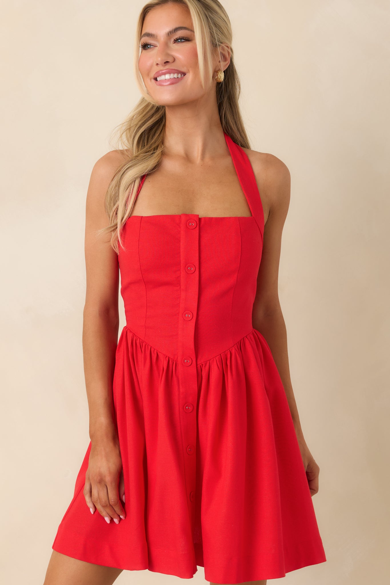 Midsection crop of mini dress showing button-front bodice and fitted waistline.
