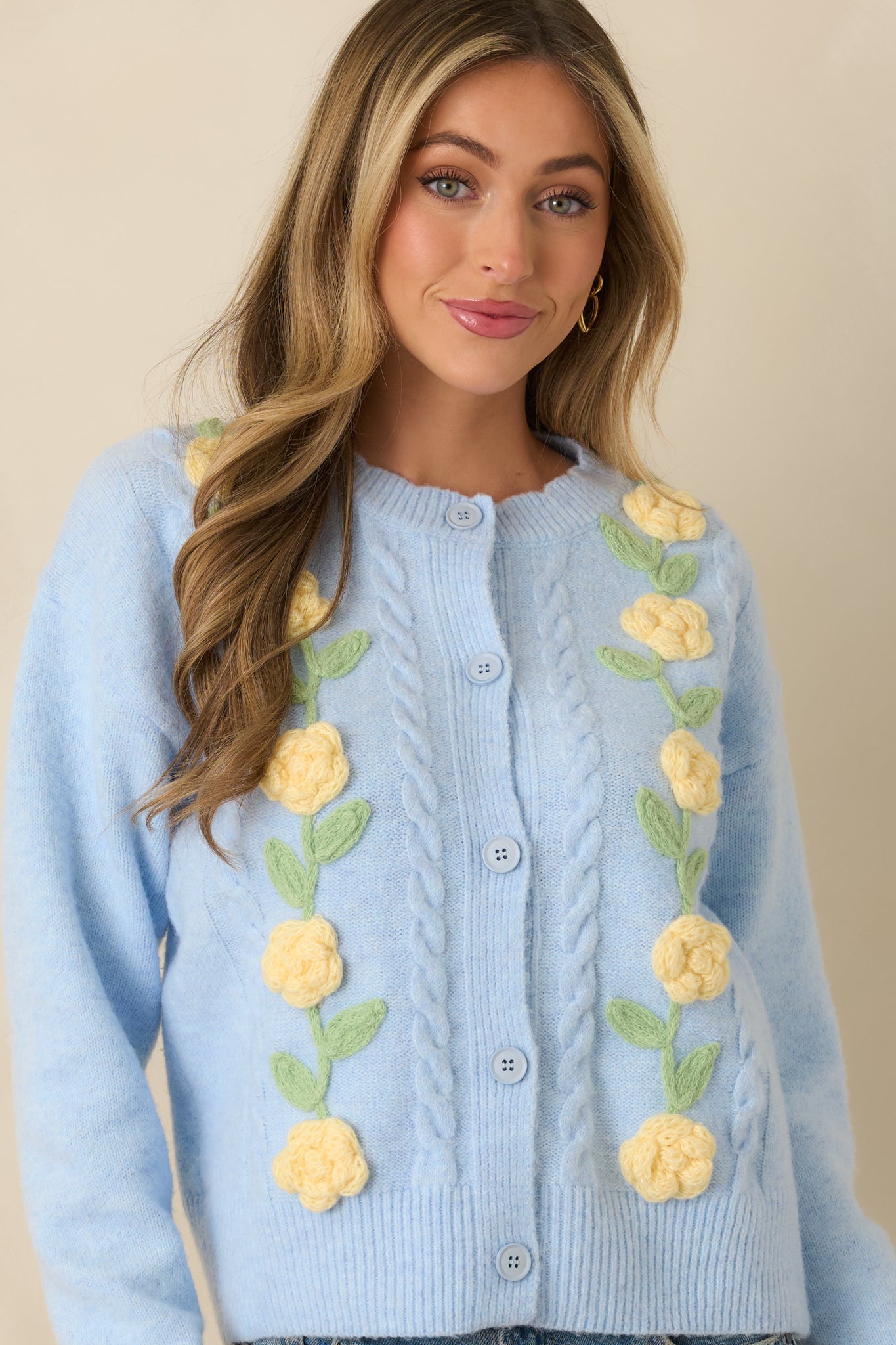 Midsection crop showing button closure and floral appliqué details along front panels.