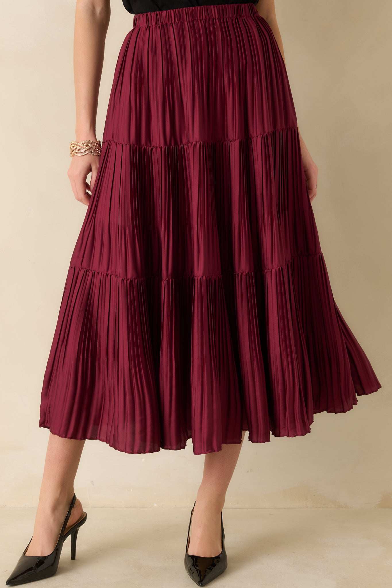 Midsection crop emphasizing the elastic waistband and top tier of the pleated skirt.
