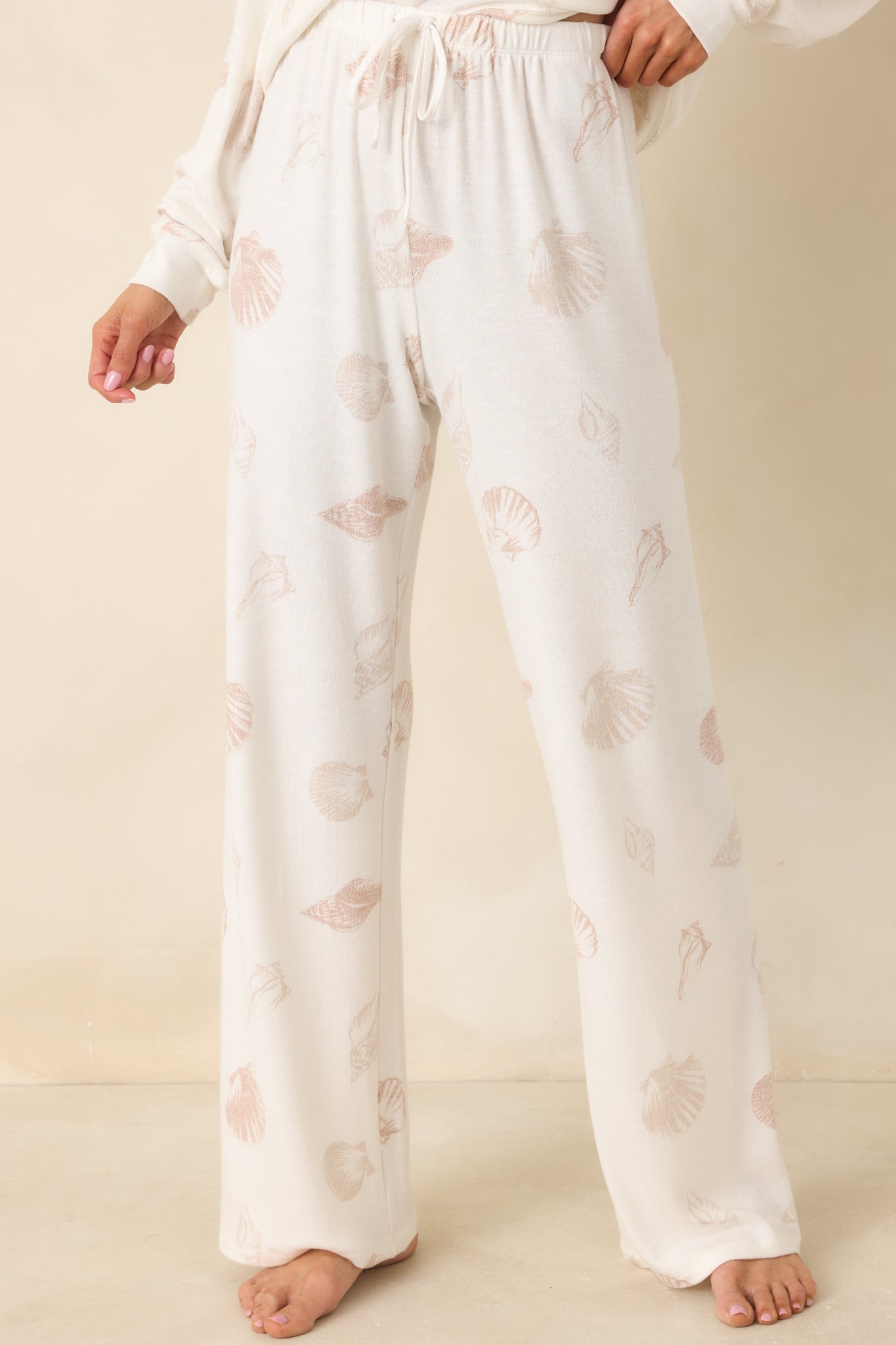 Midsection view of ivory lounge pants showcasing gathered elastic waist and smooth, breathable knit texture.