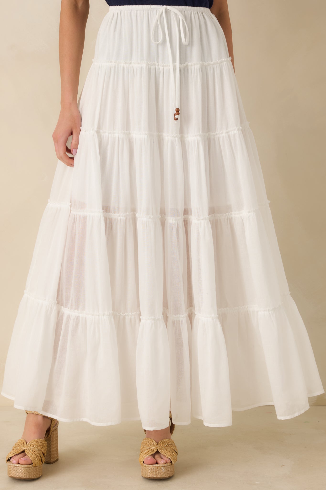 Midsection view of ivory maxi skirt showing tiered construction and relaxed pull-on style.