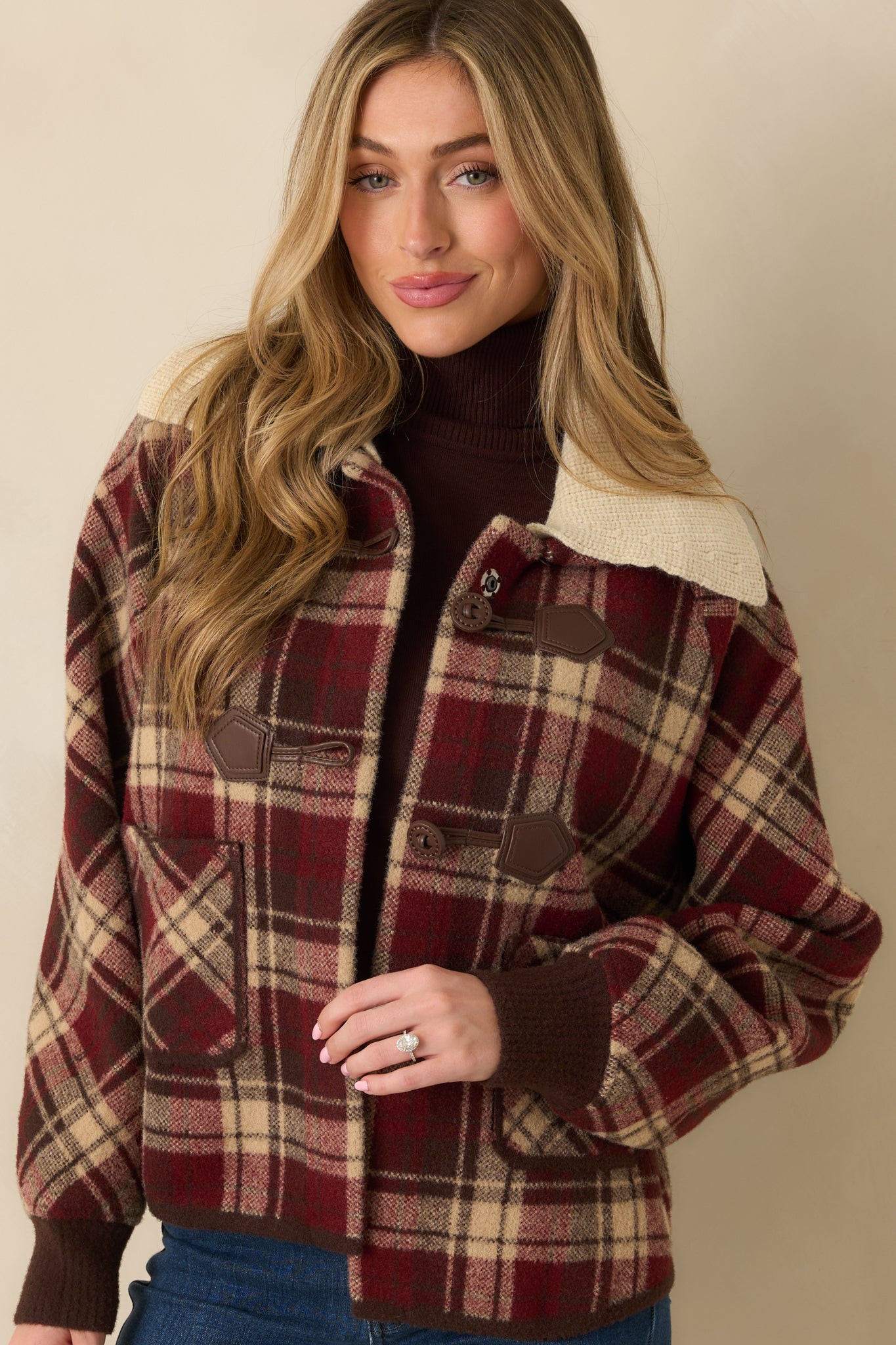 Cropped midsection view showing front pockets, ribbed cuffs, and plaid fabric texture.