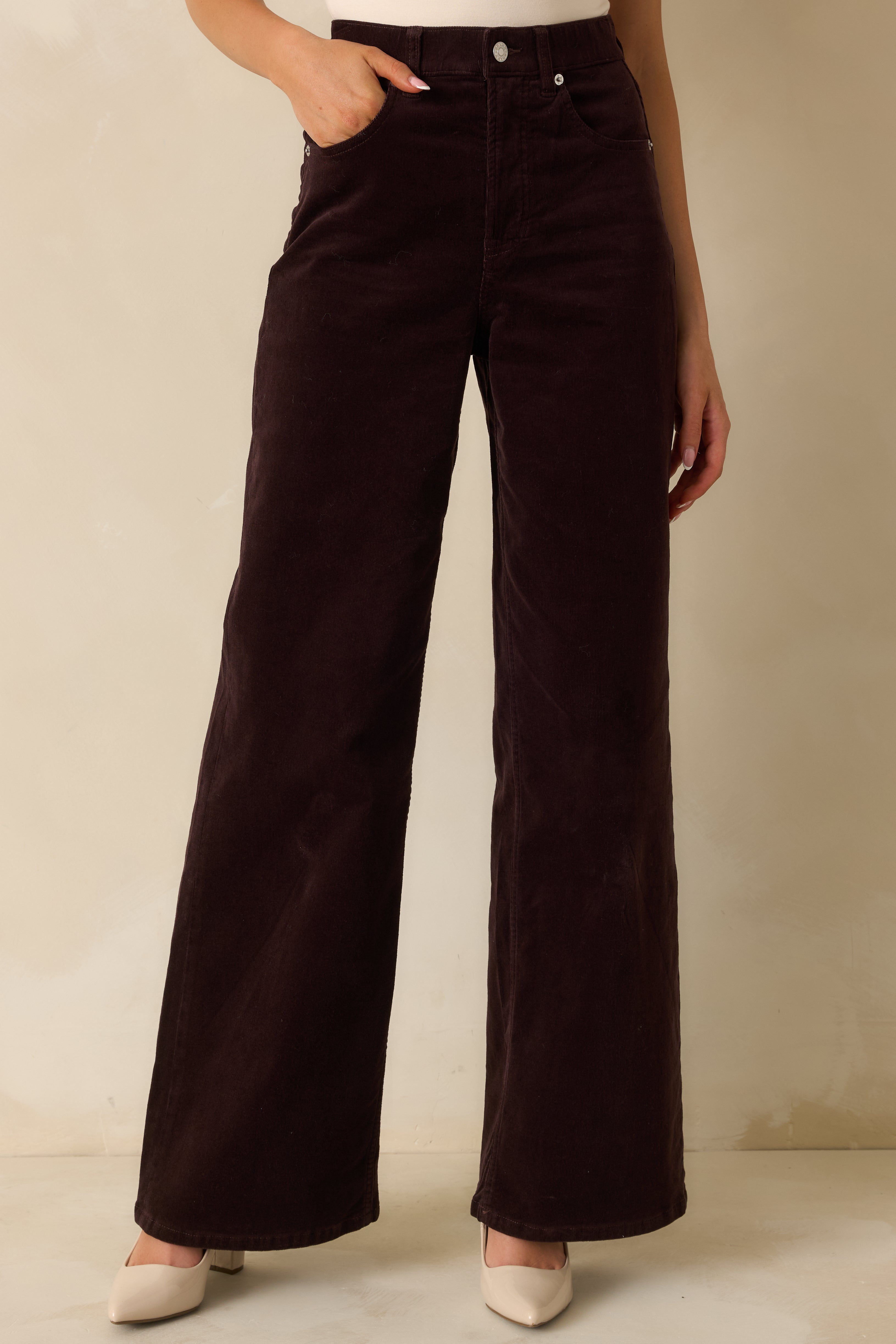 Midsection focus on wide-leg corduroy pants with zip fly, button closure, and belt loops.