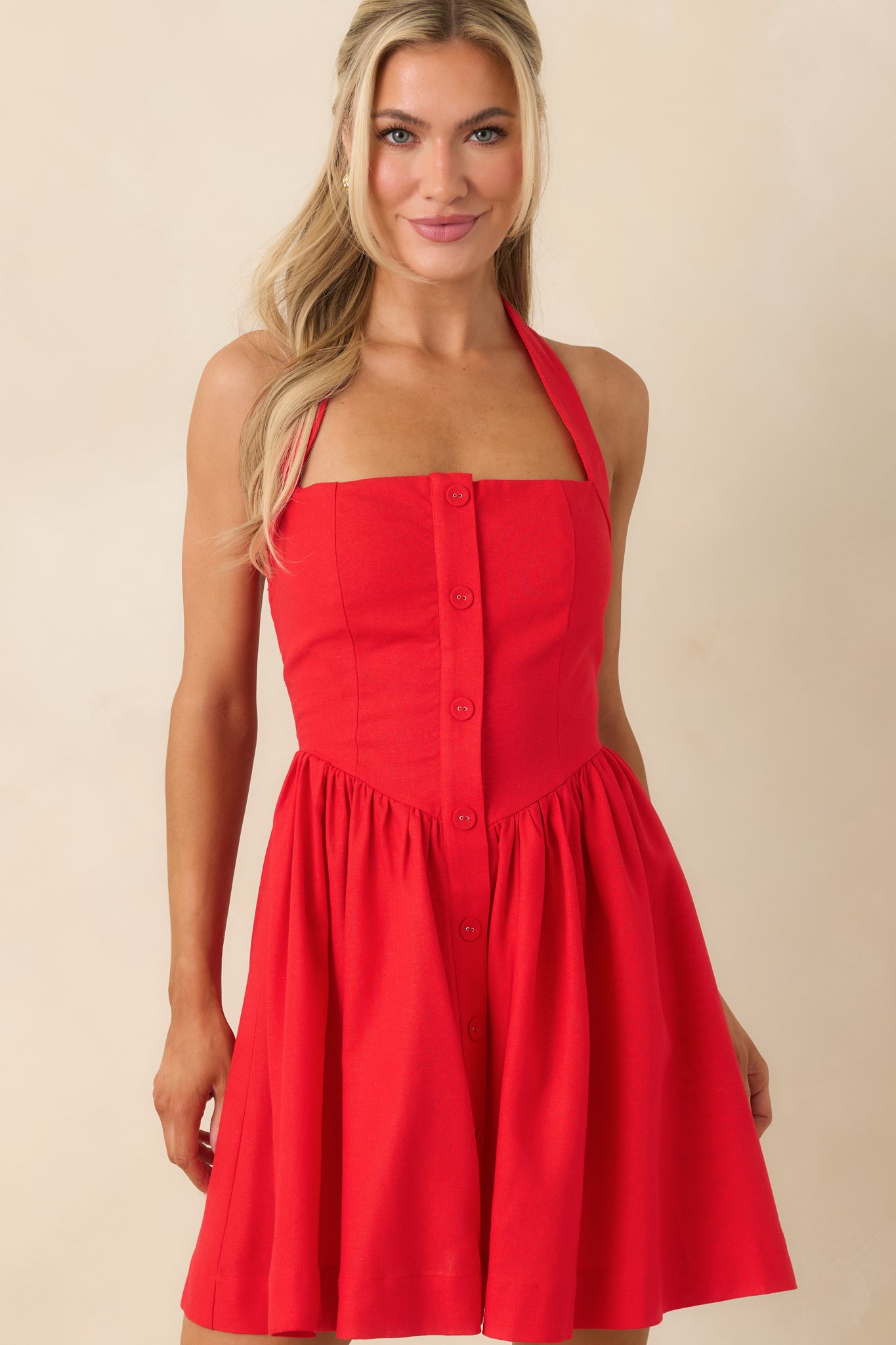 Detail of mini dress bodice showing buttons, halter neckline, and tailored fit.