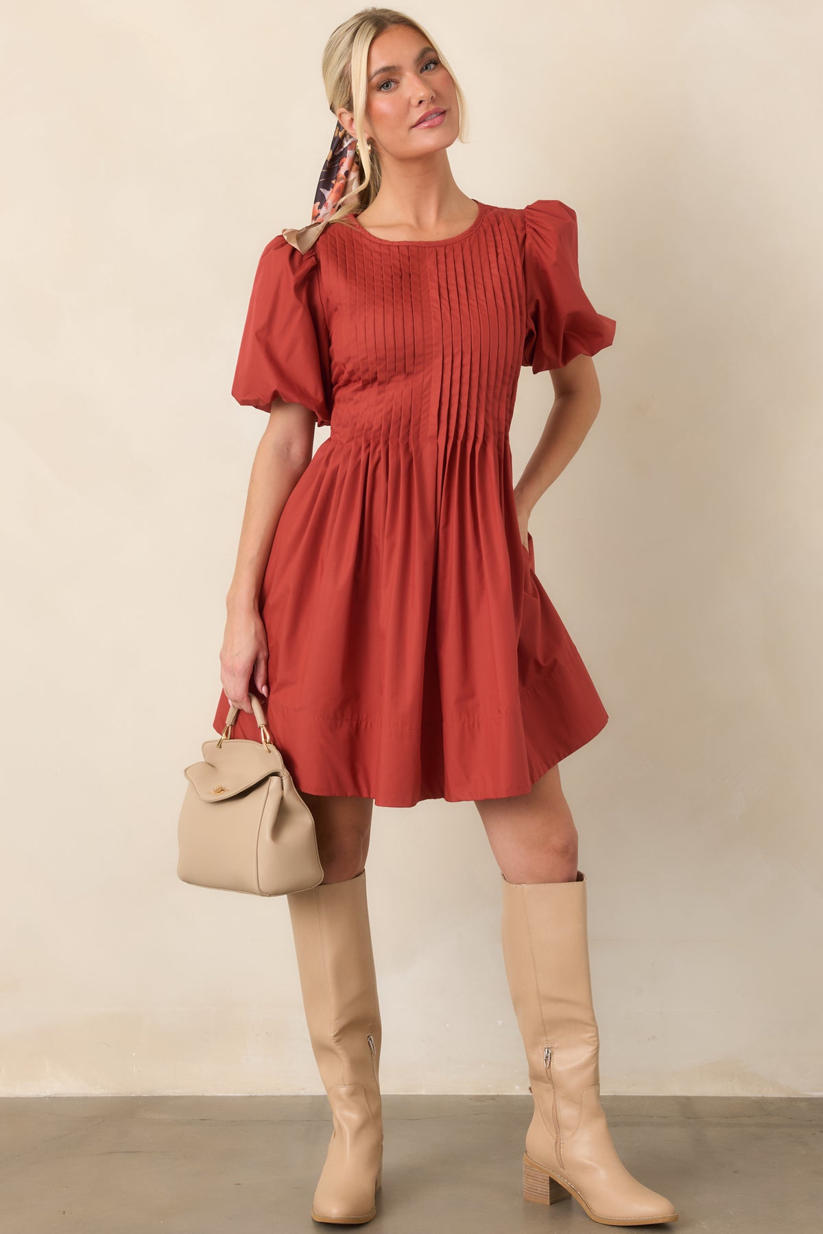 Mini dress features detailed pintucking through the front bodice, short puff sleeves, and a softly gathered full skirt.