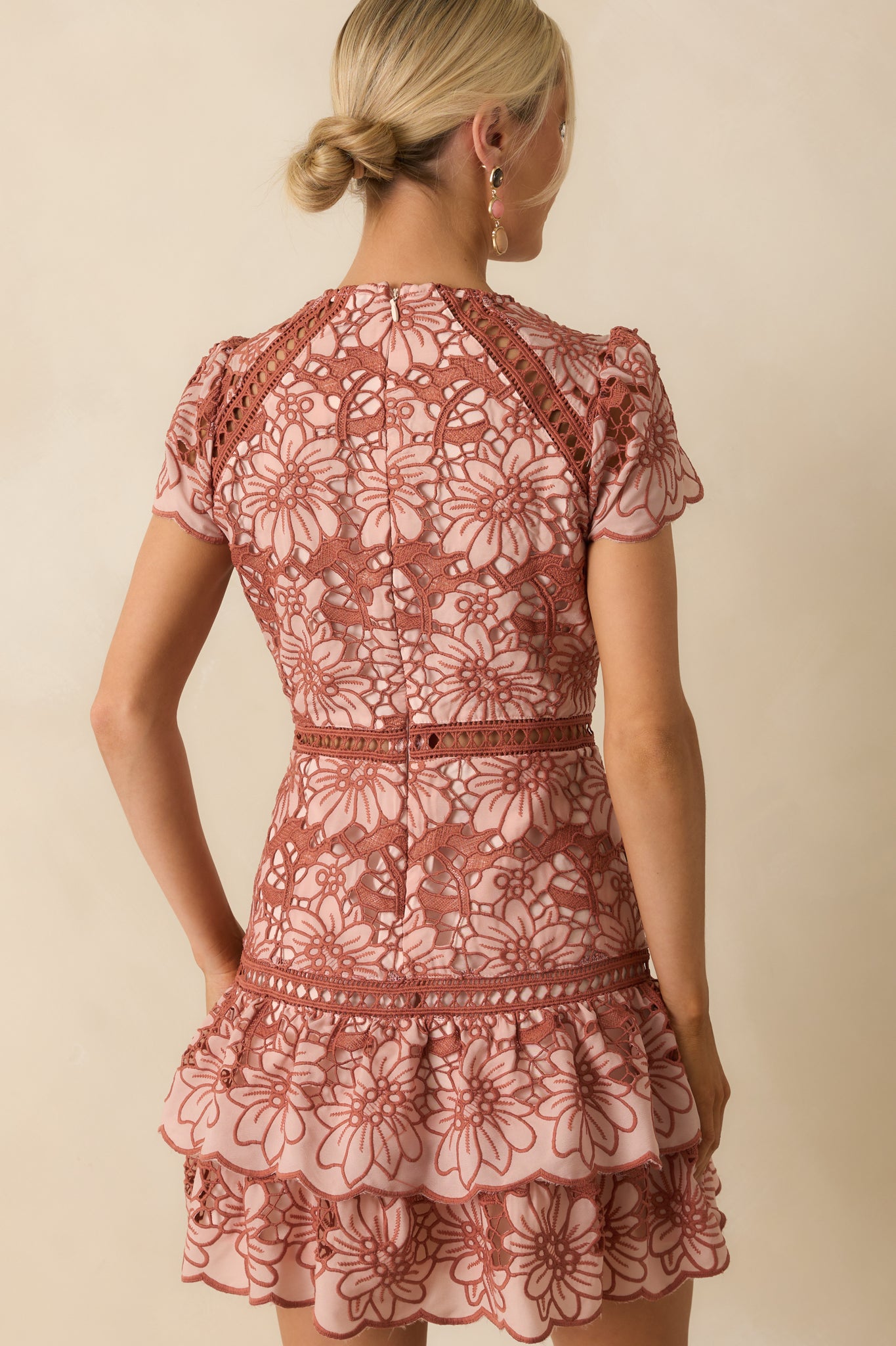 Rear view of the mini dress showing the hidden back zipper and floral lace overlay.