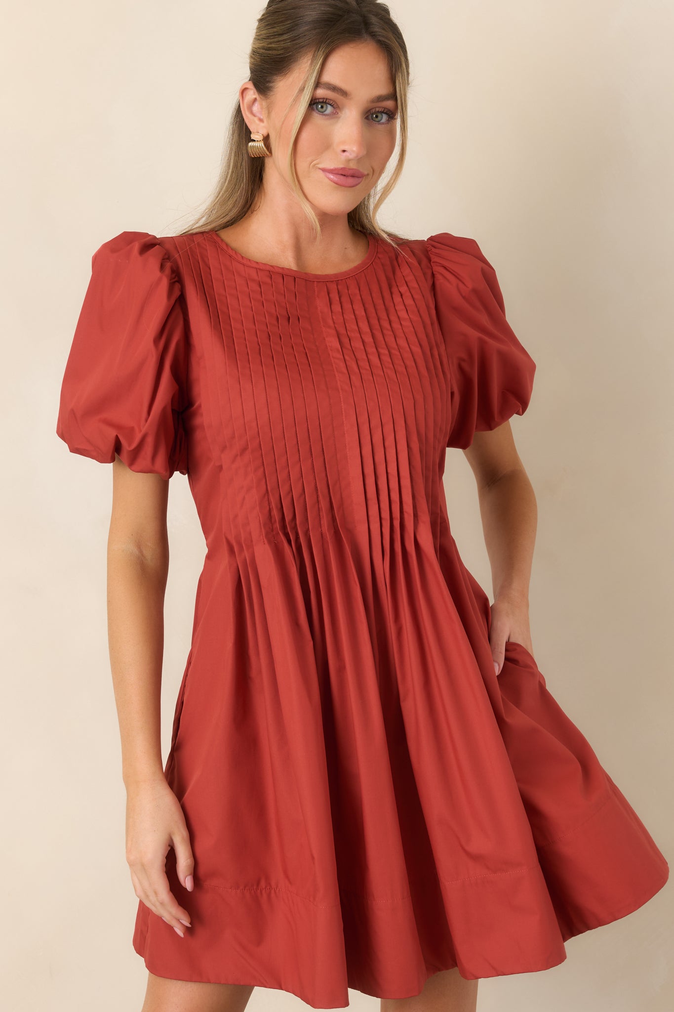 Short puff sleeves create dimensional shape at the shoulders above the intricately pintucked dress bodice.