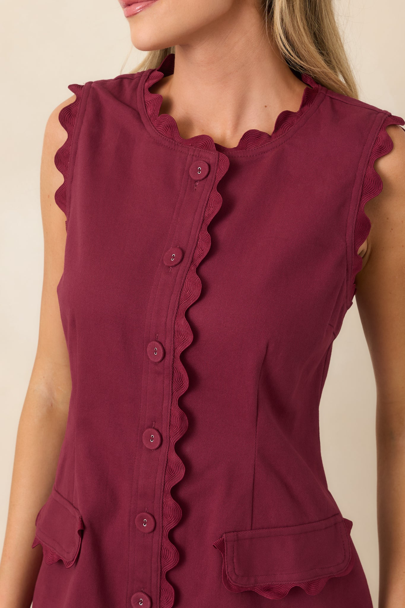 Close-up highlights the tonal ric rac trim, covered button, shaping seam, and textured cotton-rich stretch fabric.