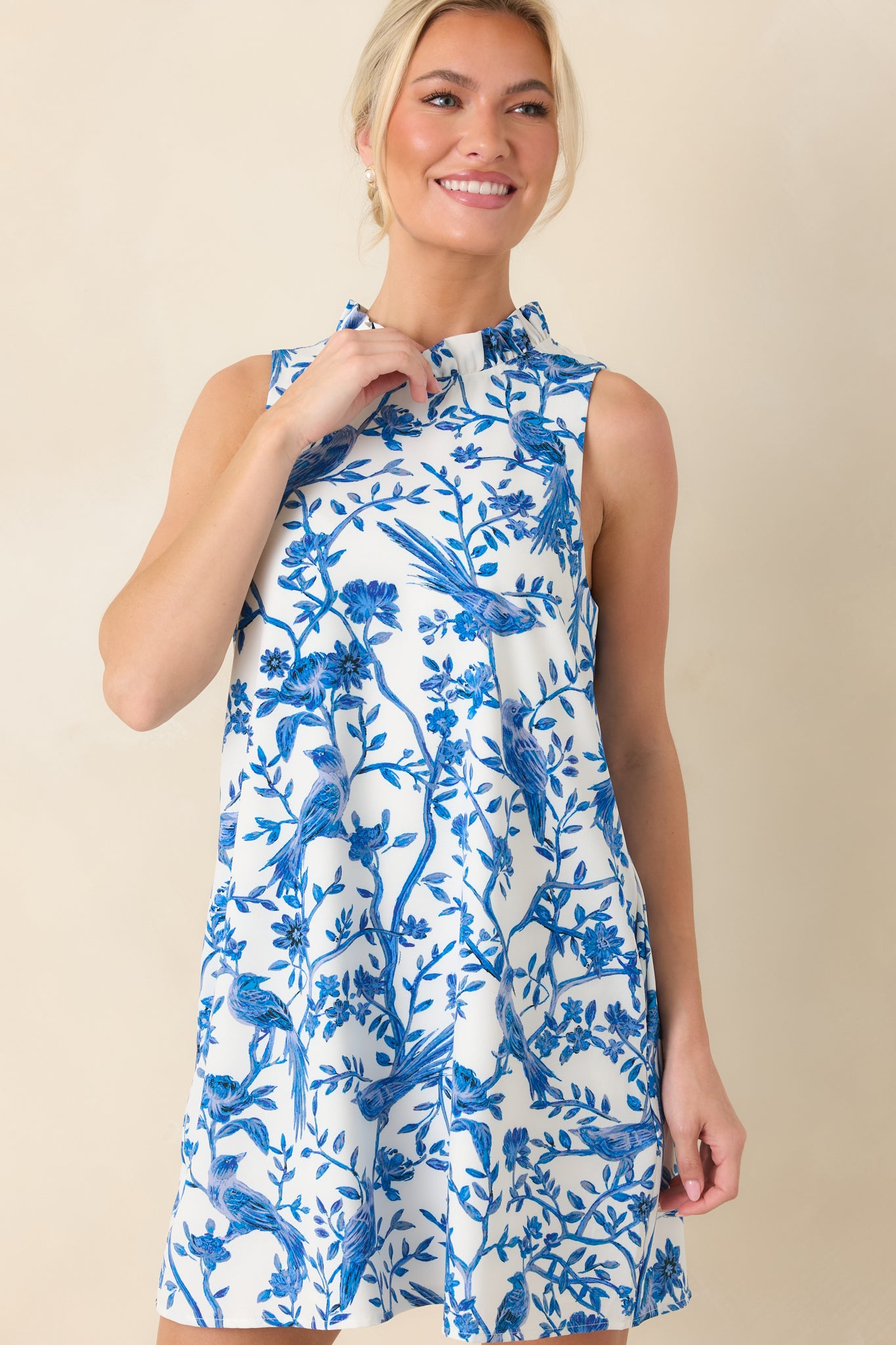 Mini dress showing the sleeveless cut, shift silhouette, and evenly printed botanical design.