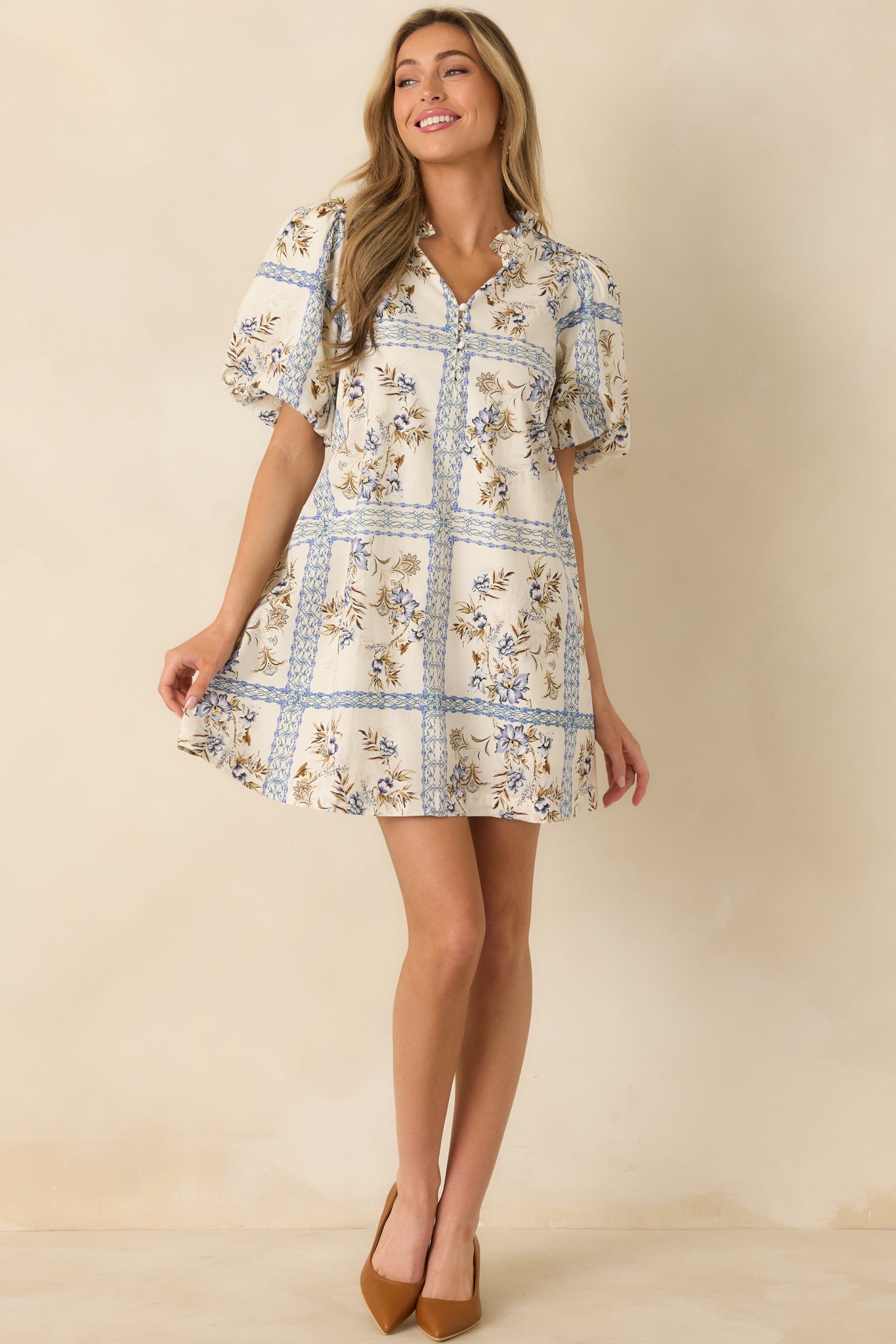 Mini dress with a split V-neckline framed by soft ruffle trim and a functional button front.