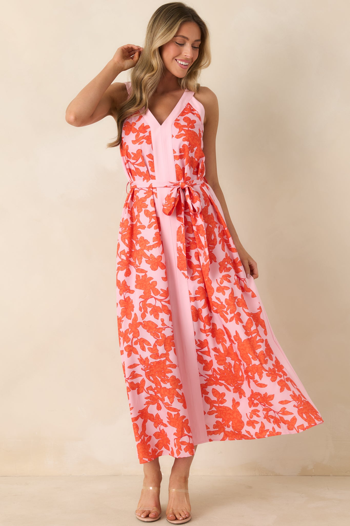 Mini dress with bright orange floral print on soft pink background, V-neckline, and flowing skirt.