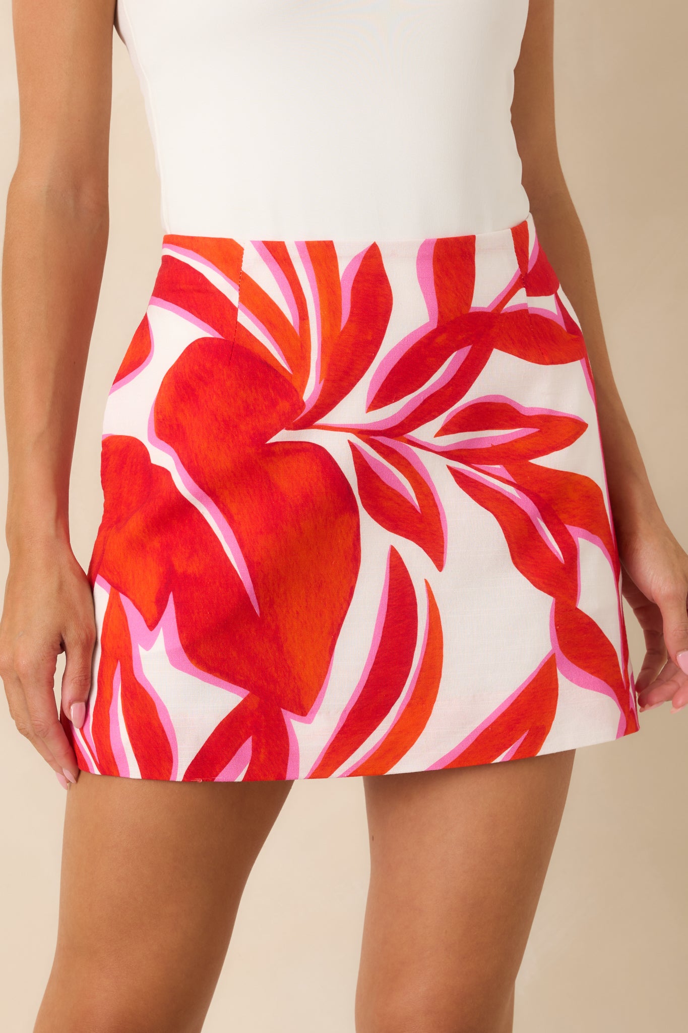 Mini skirt detail highlighting the tailored seams and polished woven fabrication.