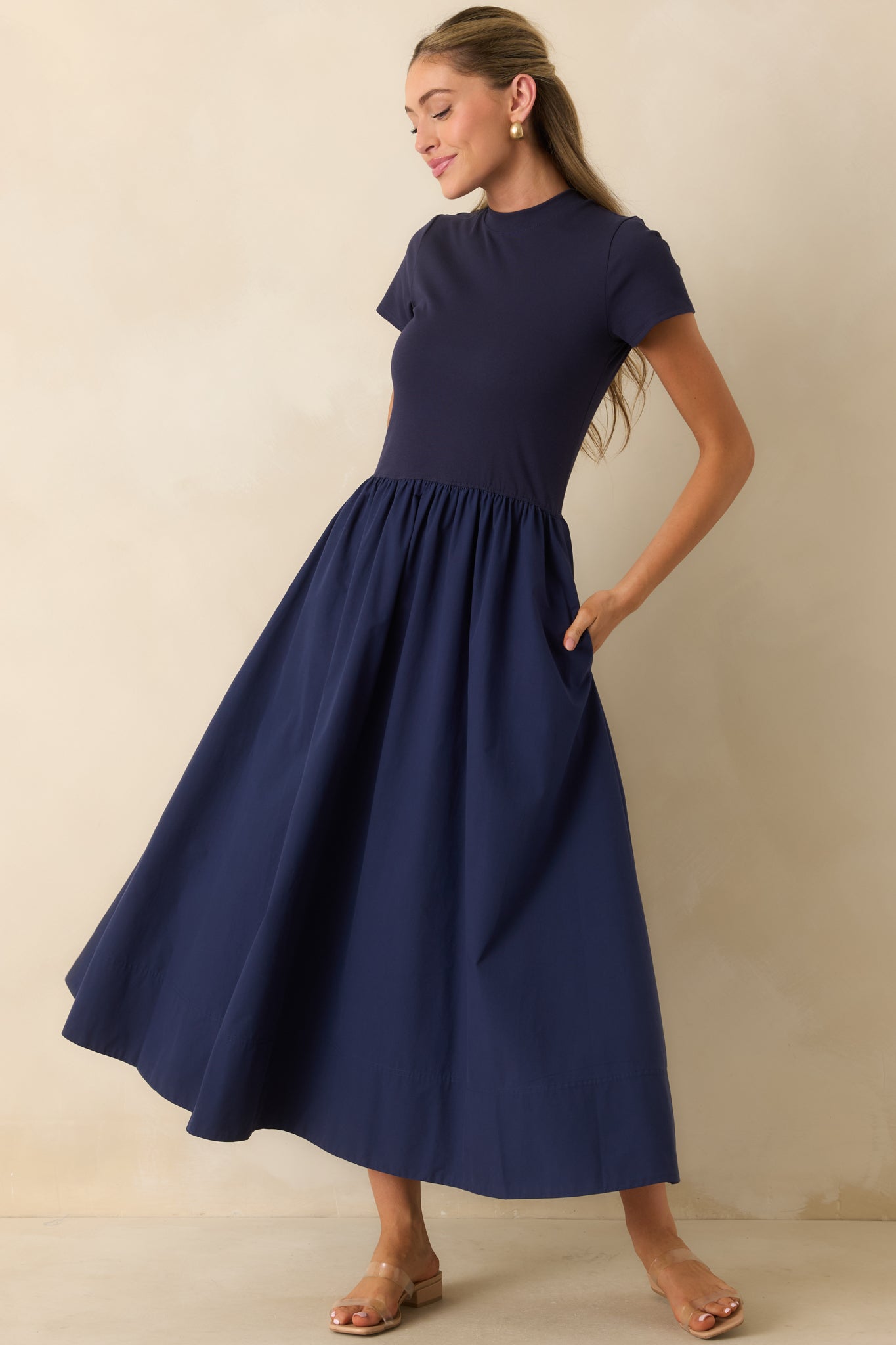 Minimalist midi dress with a structured mock neck, tailored bodice, and flowing full skirt silhouette.