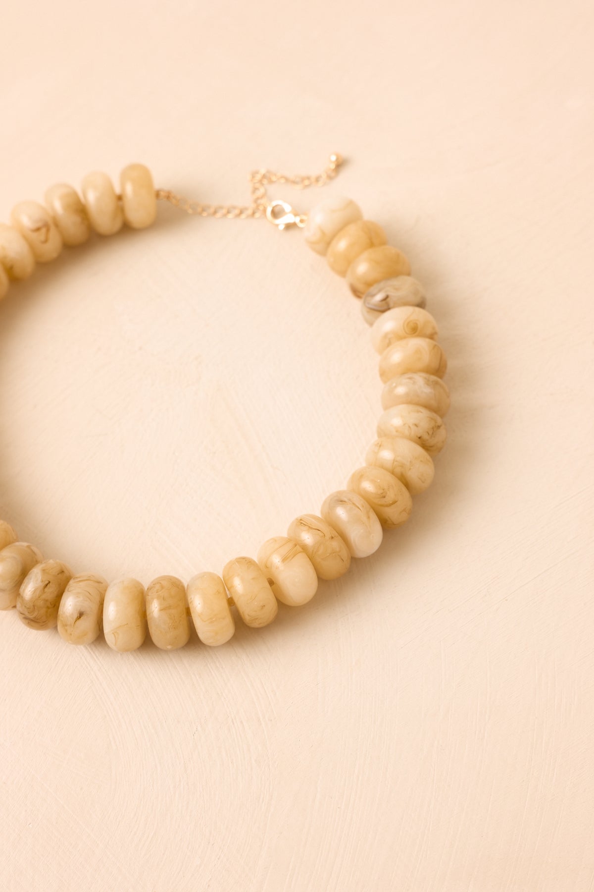 Minimalist necklace with a softly curved shape presented against a neutral backdrop for a polished look.