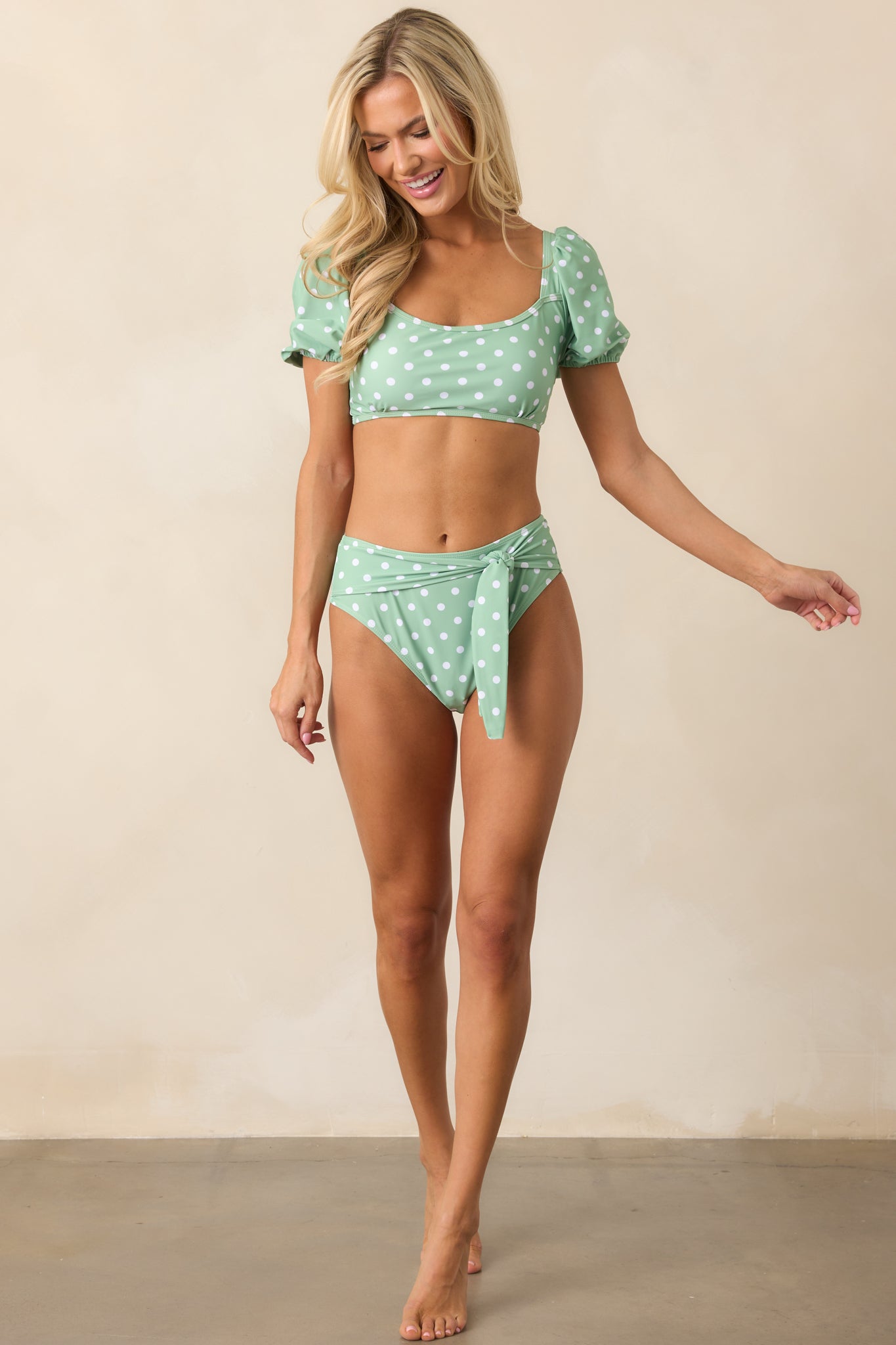 A full-body shot of the mint bikini bottoms, showcasing the high-rise design, polka dot print, and self-tie front detail.