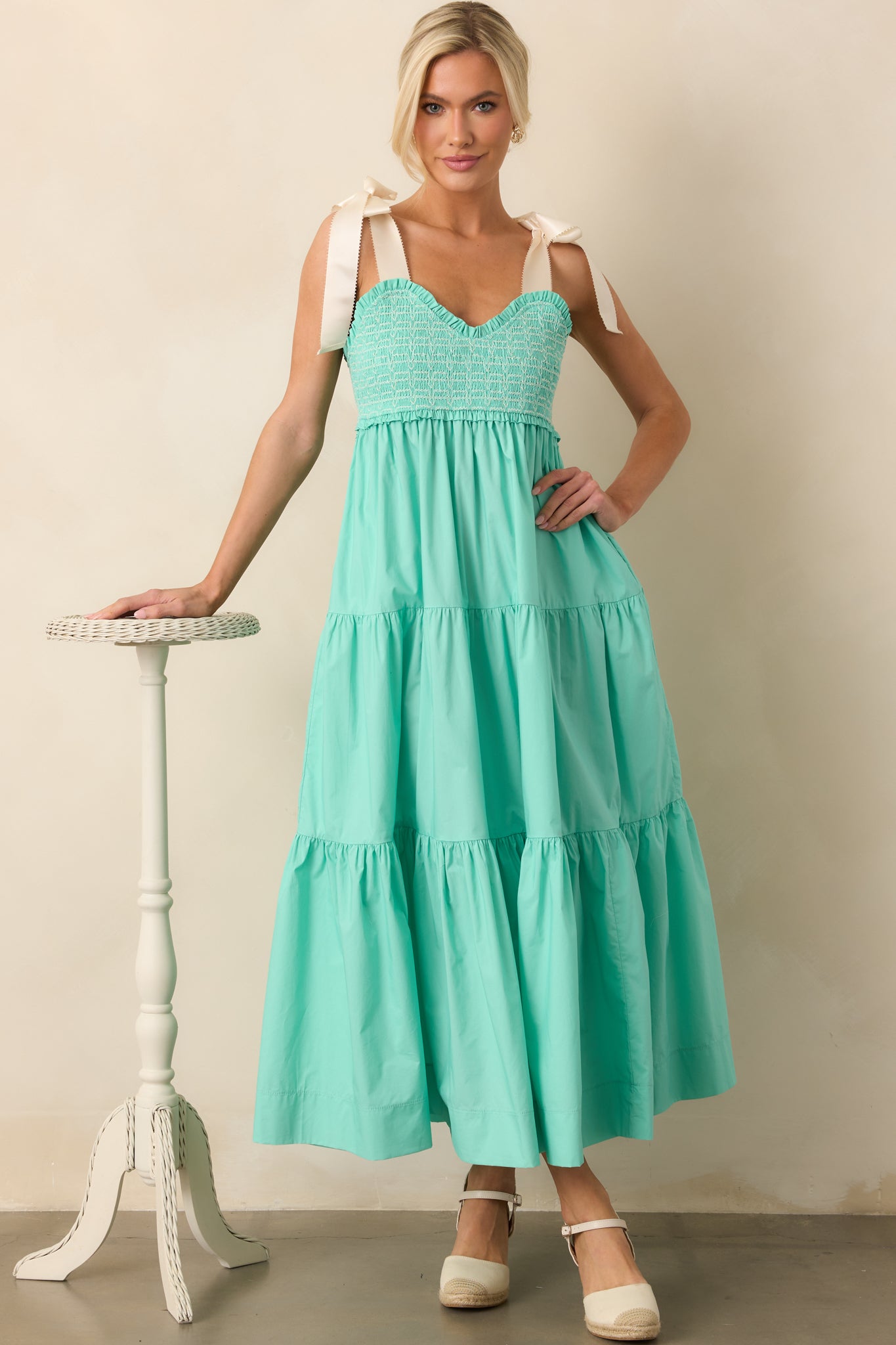  A mint green midi dress featuring a sweetheart neckline, fully smocked bust, and delicate white embroidered detailing.