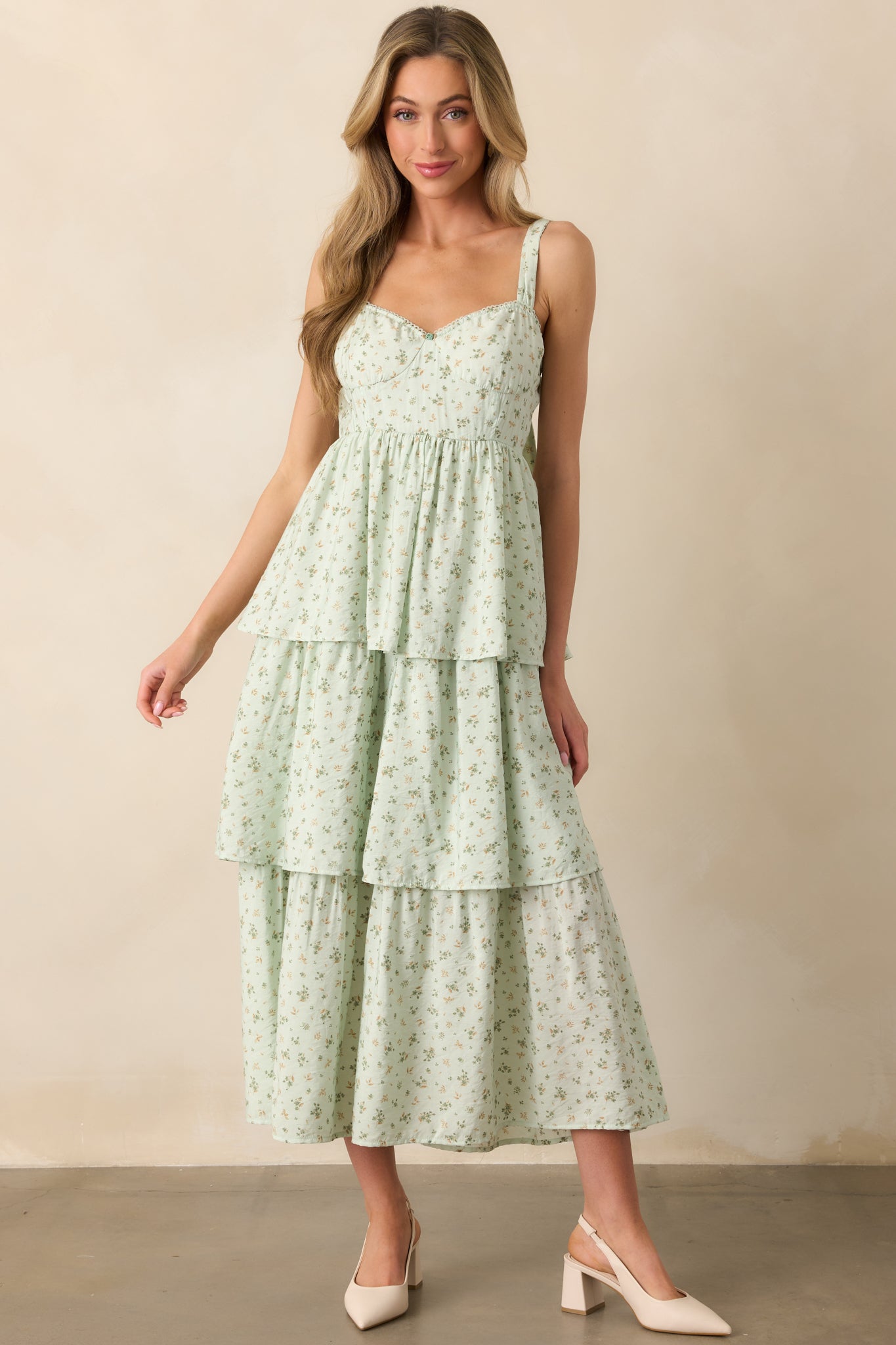 A full-body front view of a mint floral maxi dress, featuring an elastic sweetheart neckline, adjustable straps, and bustier-style stitch detailing in the bodice. The tiered skirt and smocked back panel add movement to the design