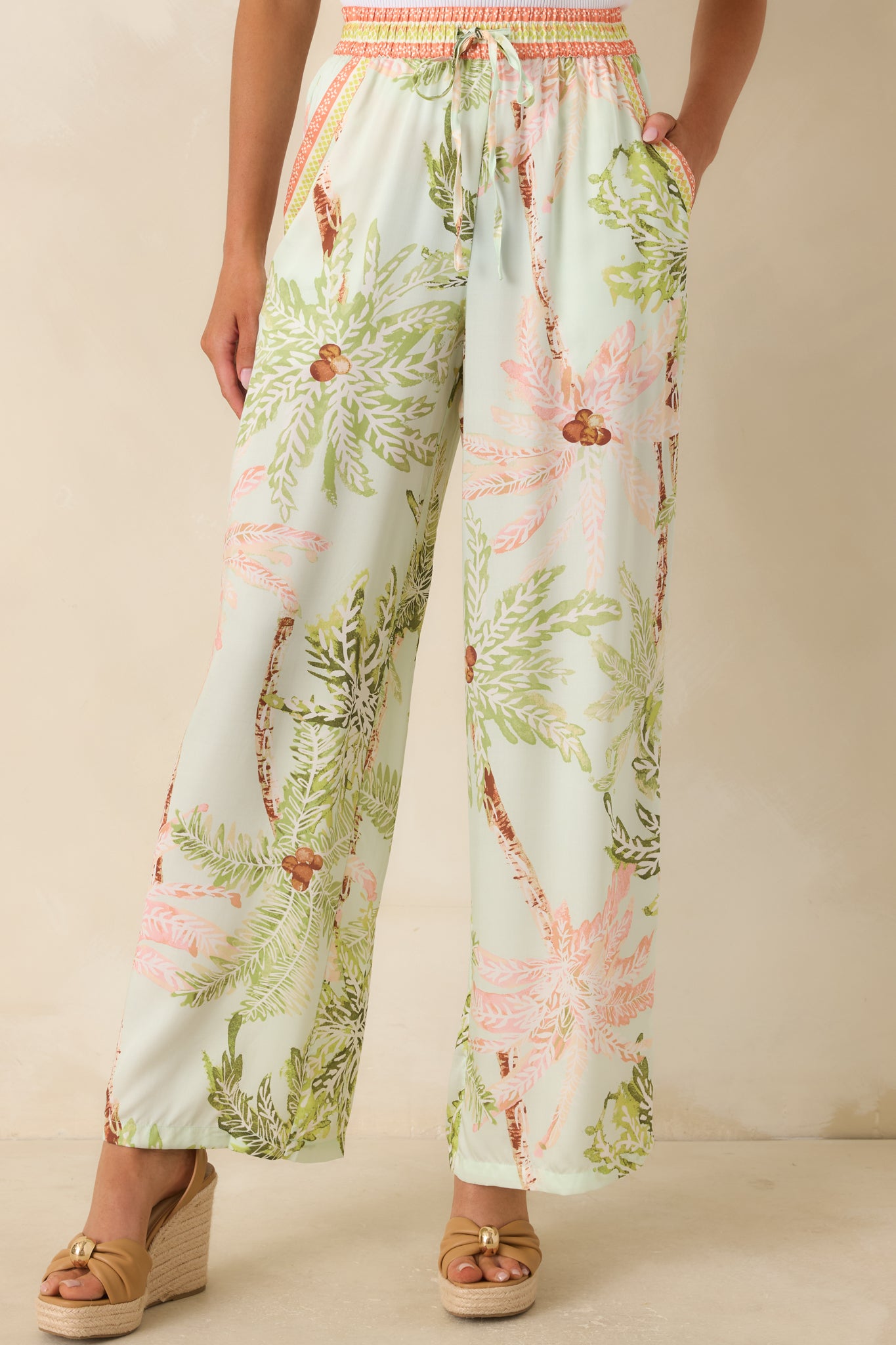 Mint pants featuring contrast-trimmed side pockets and soft watercolor-inspired palm print.