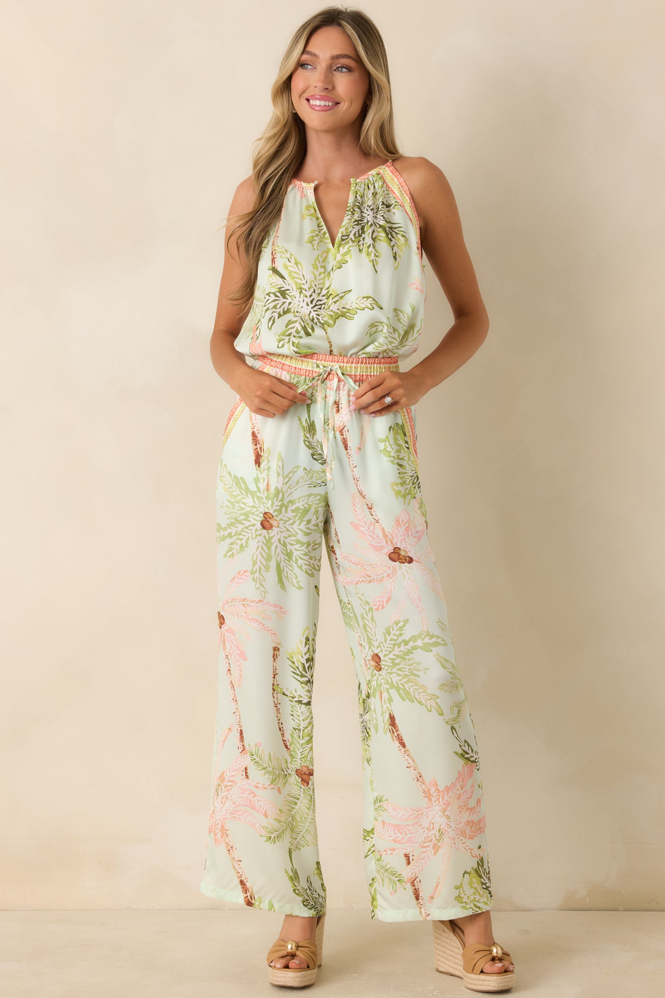 Mint tropical print pants featuring a wide-leg silhouette, elastic waistband, and relaxed fit in a watercolor palm print.