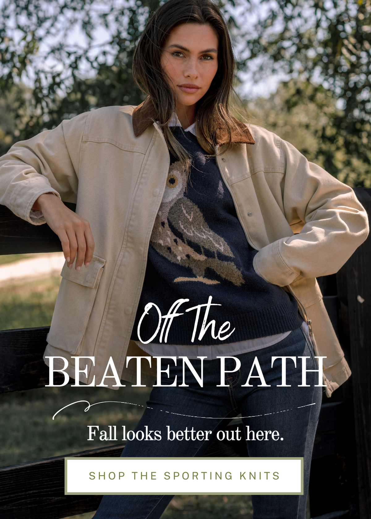 Model wearing a navy owl knit sweater with a tan jacket. Text reads: "Off The Beaten Path. Fall looks better out here."