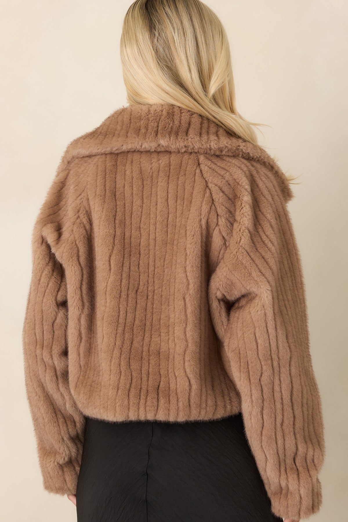 Rear view of the mocha brown faux fur jacket showing its cropped silhouette and ribbed texture.