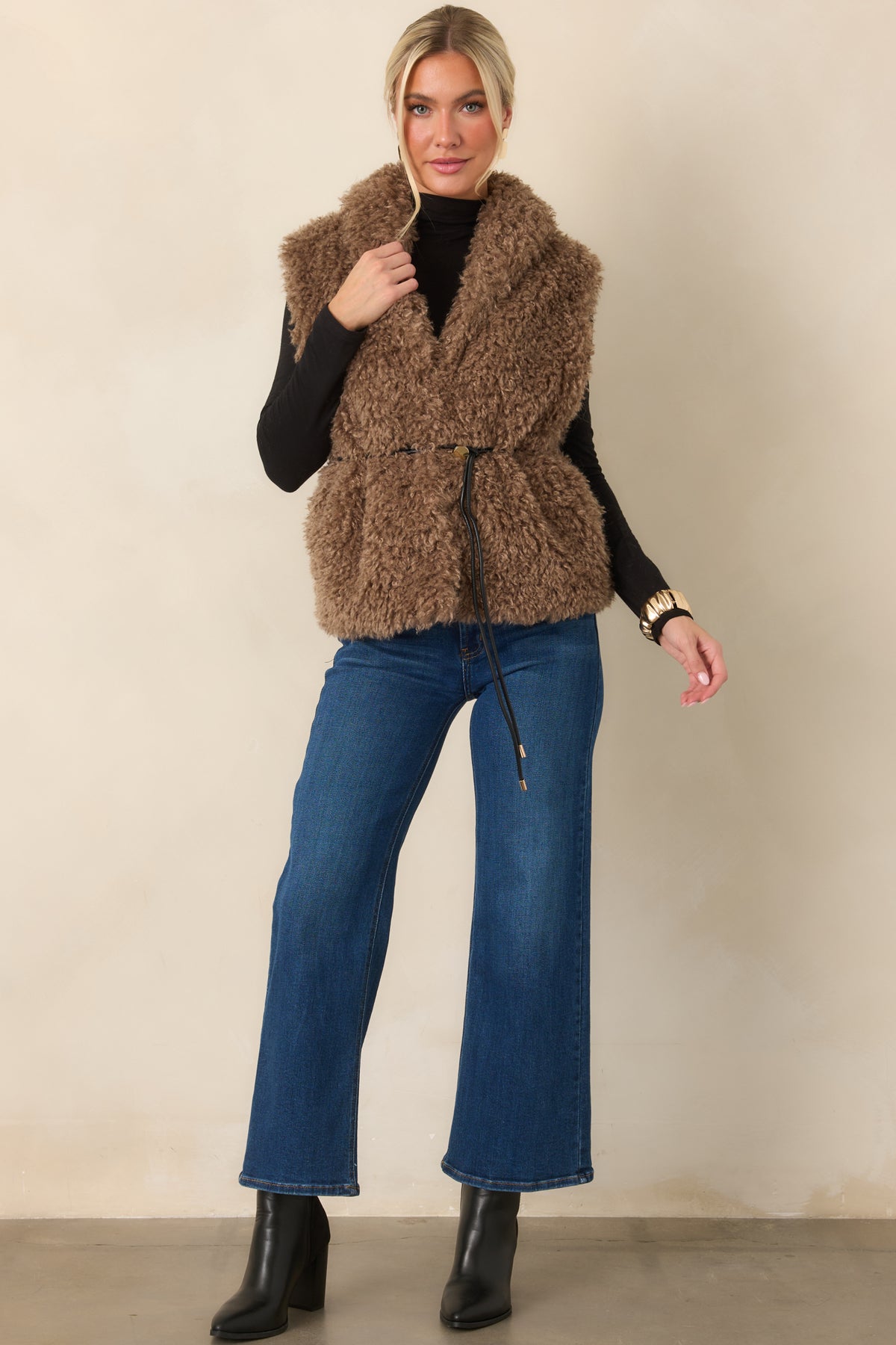 Faux fur vest with an oversized shawl collar and removable faux leather drawcord belt for versatile styling.