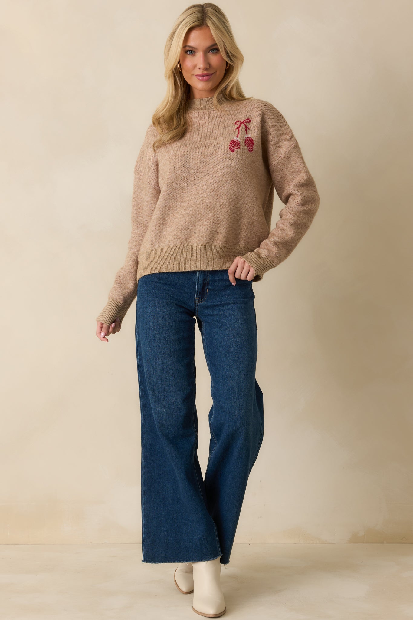 Cozy mocha sweater featuring a loose silhouette, ribbed detailing, and seasonal red mitten embroidery at the front.