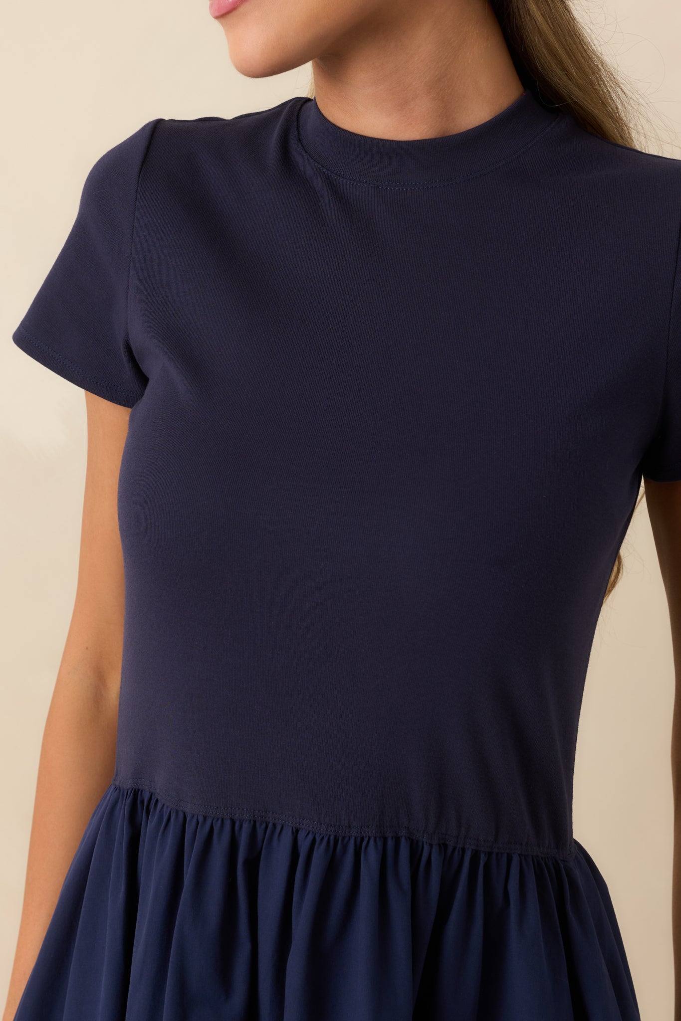 Close-up of the mock neckline and soft cotton fabric highlighting the dress's clean minimalist design.