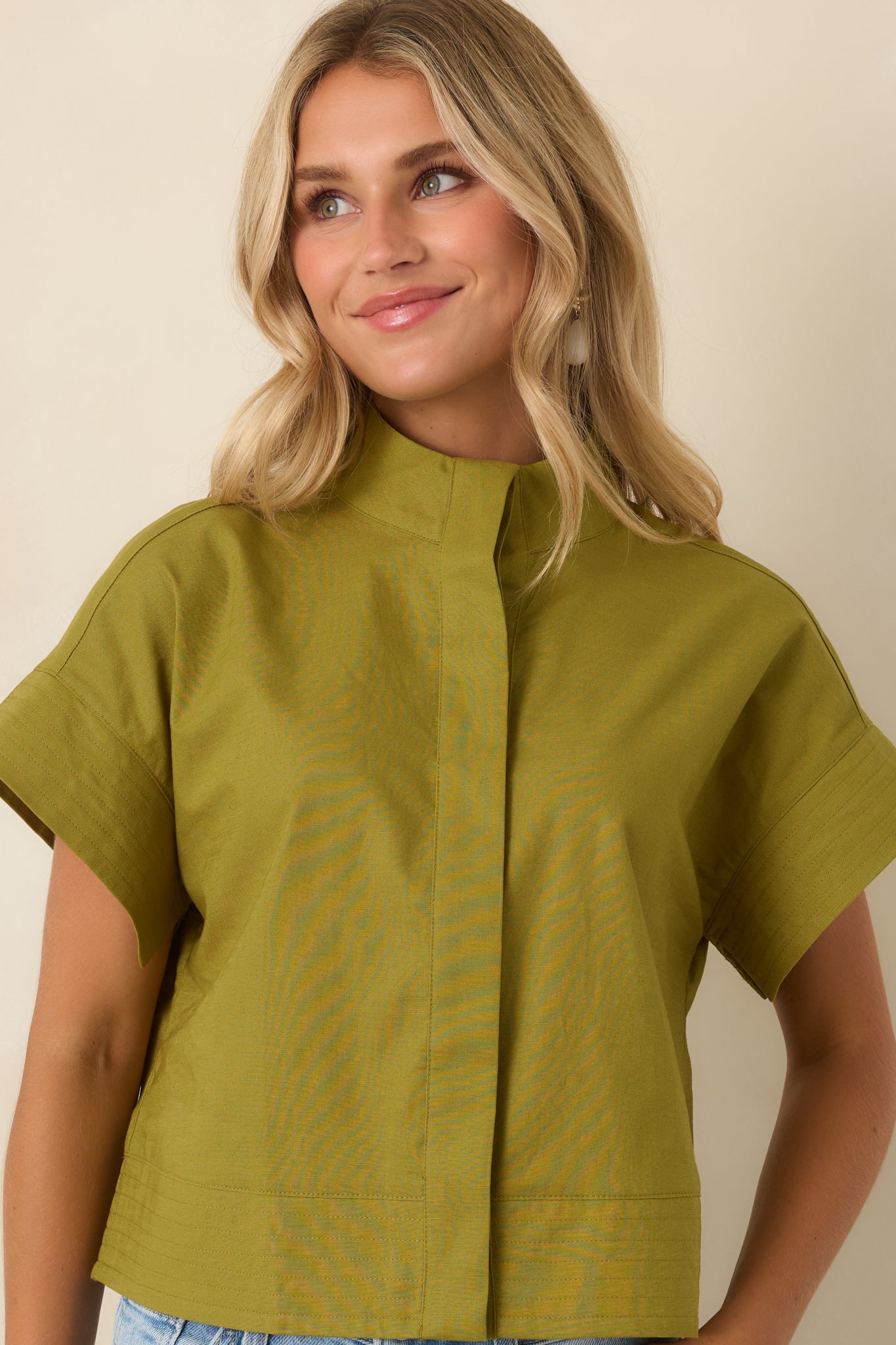 Mock neckline and concealed button-front placket highlight the clean, tailored styling of this olive green cotton linen top.