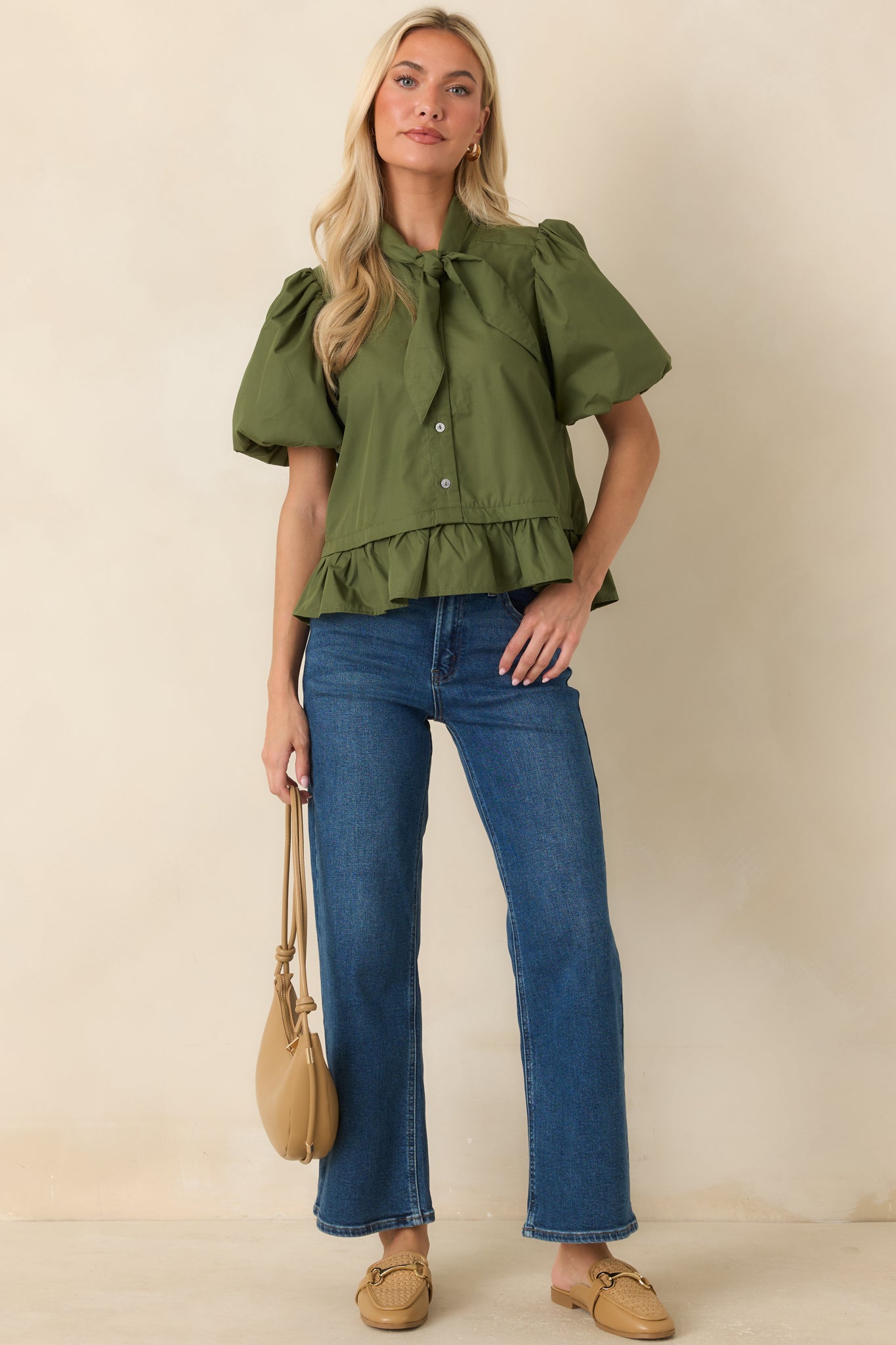 Moss green blouse featuring a rich solid hue, voluminous puff sleeves, a bow tie neckline, and a graceful peplum silhouette.