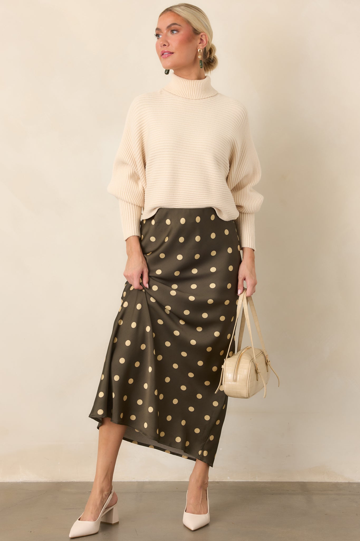 Moss green satin midi skirt featuring a bias-cut silhouette, cream polka dot print, and fluid drape with graceful movement.