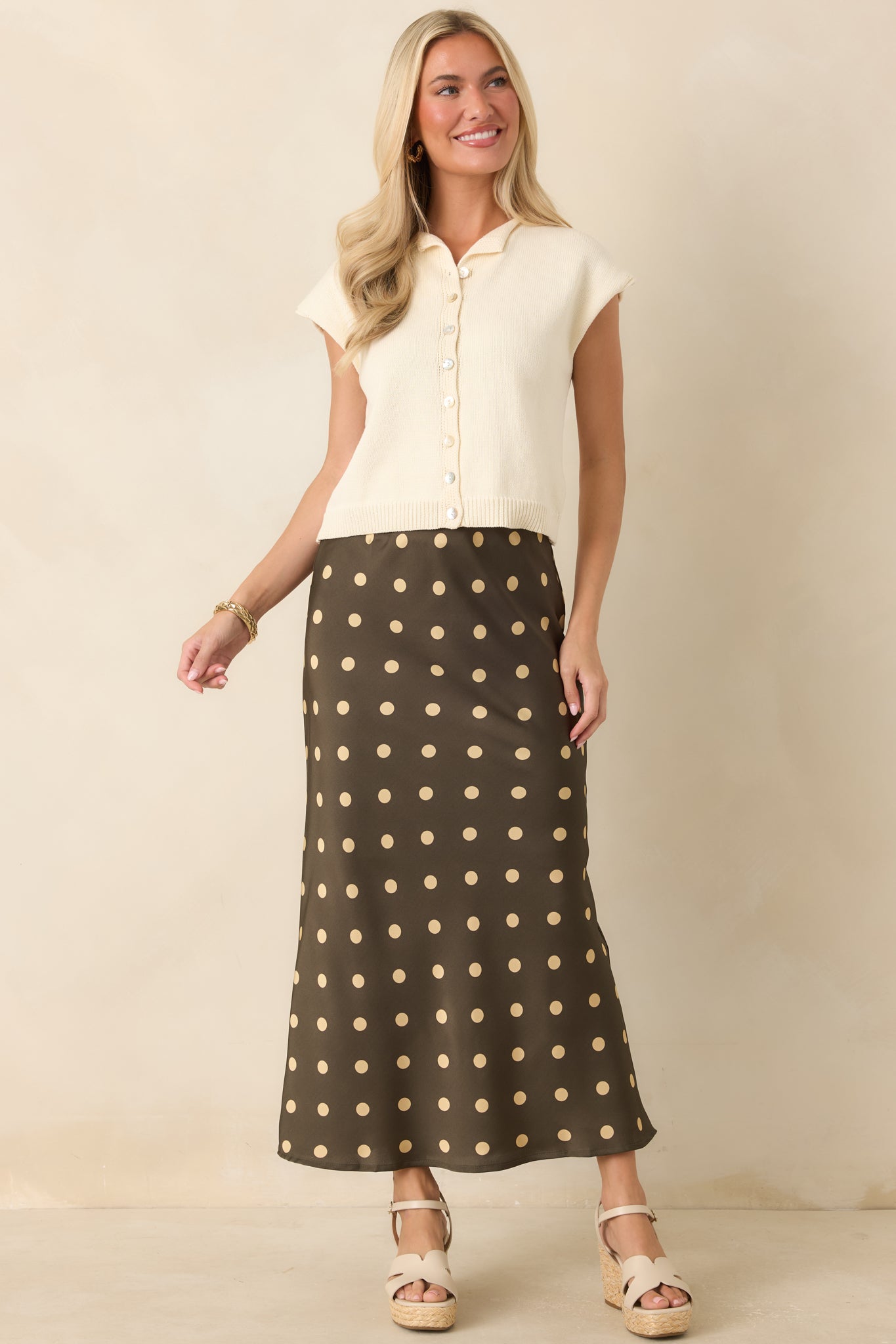 Moss green satin skirt featuring cream polka dots, a bias-cut silhouette, and elegant draping for graceful movement.