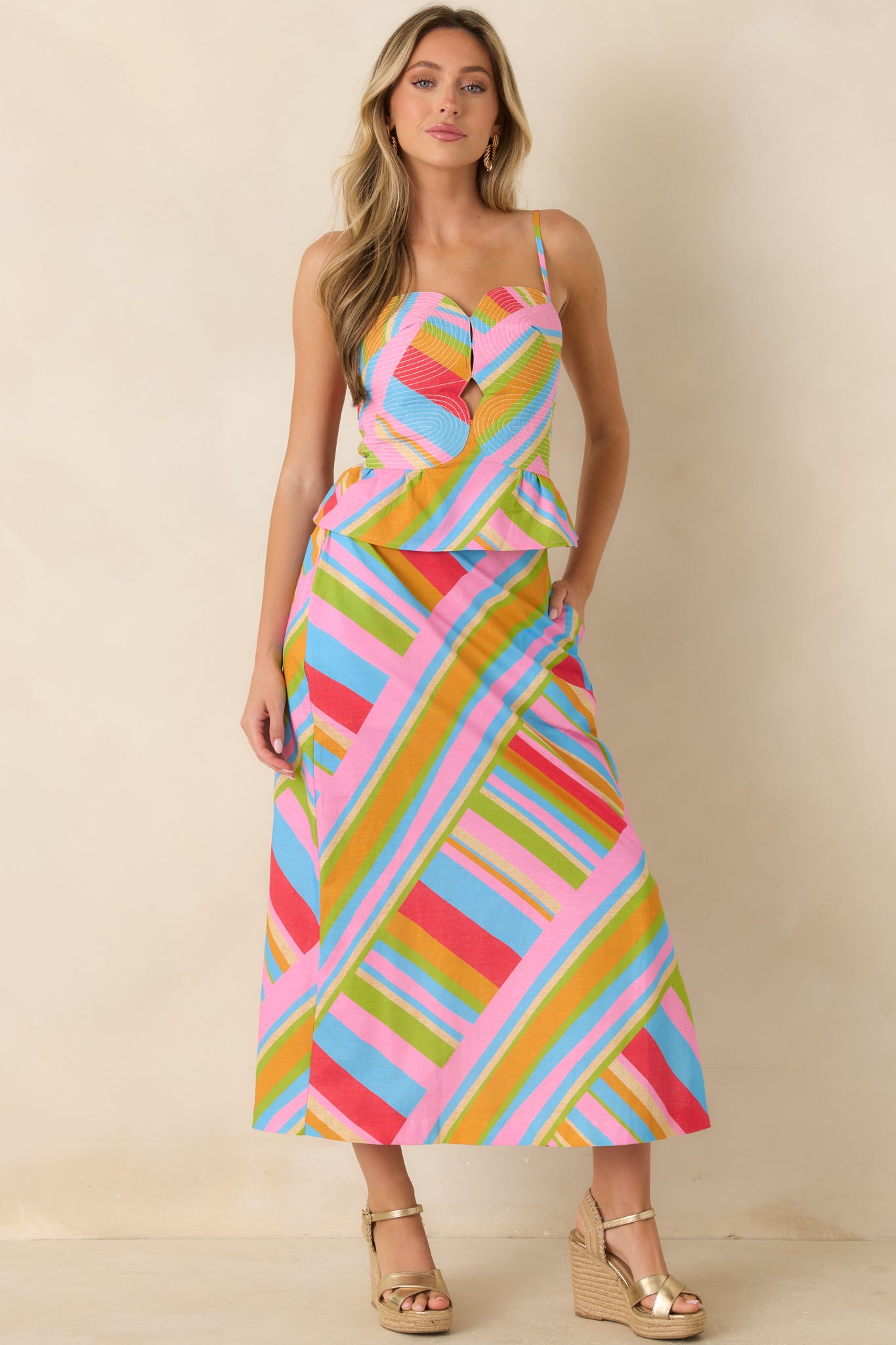 Multi geometric cotton linen peplum top featuring a sweetheart neckline, adjustable straps, center cutout detail, and vibrant colors.