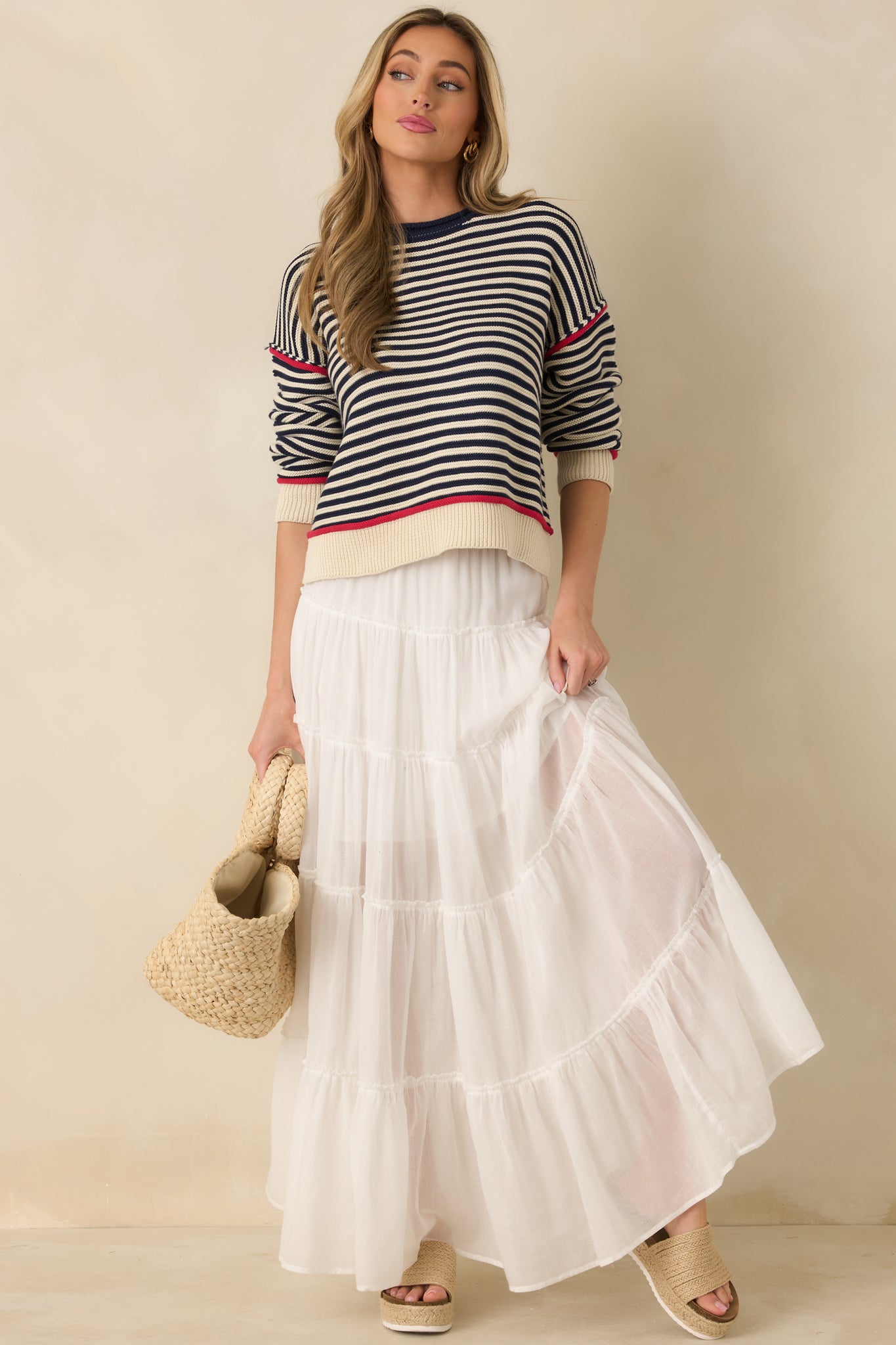 Multi-tiered ivory maxi skirt designed with adjustable drawstring waist and fluid, airy drape for movement.