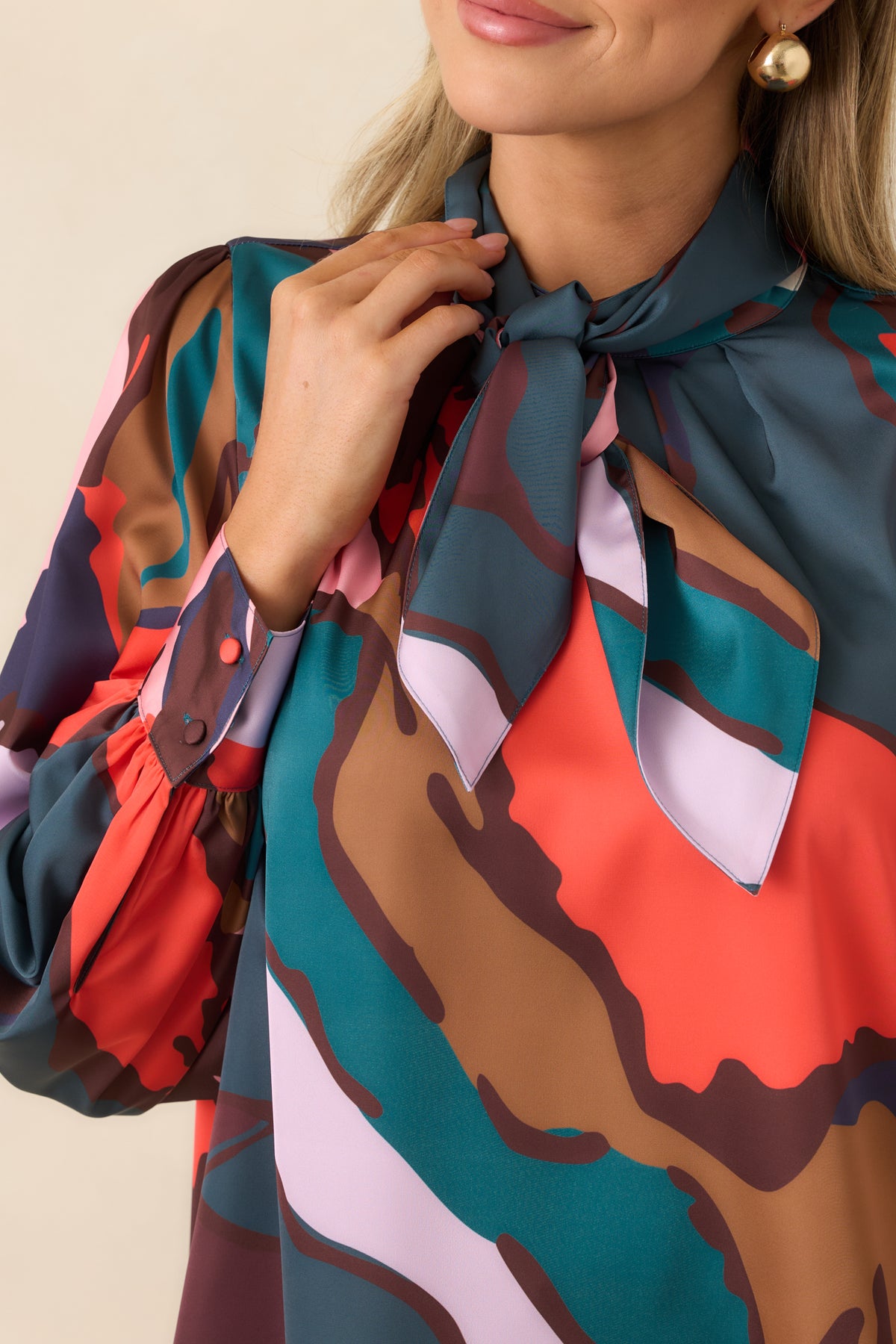 Close-up of the blouse’s subtly shiny fabric and sweeping multicolor abstract pattern.