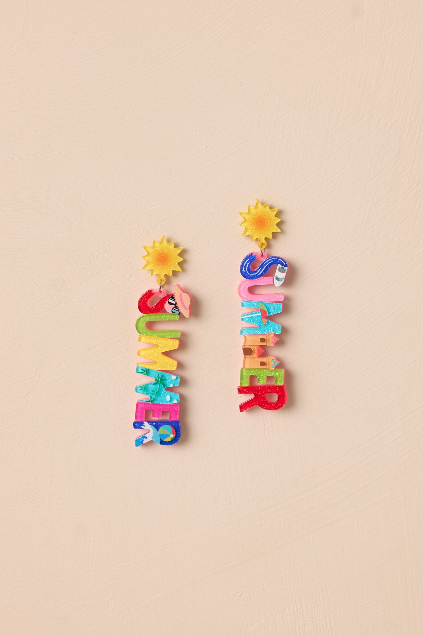 The multi-color acrylic earrings displayed against a neutral beige background, showcasing their playful design and vibrant colors.