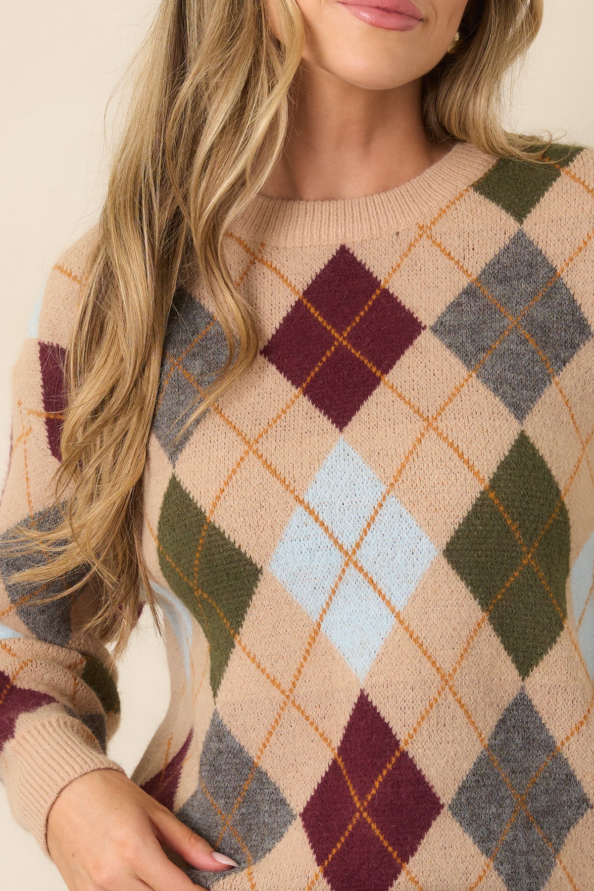 The knit texture highlights the detailed multicolor diamond pattern in burgundy, olive, grey, blue, and golden tones.
